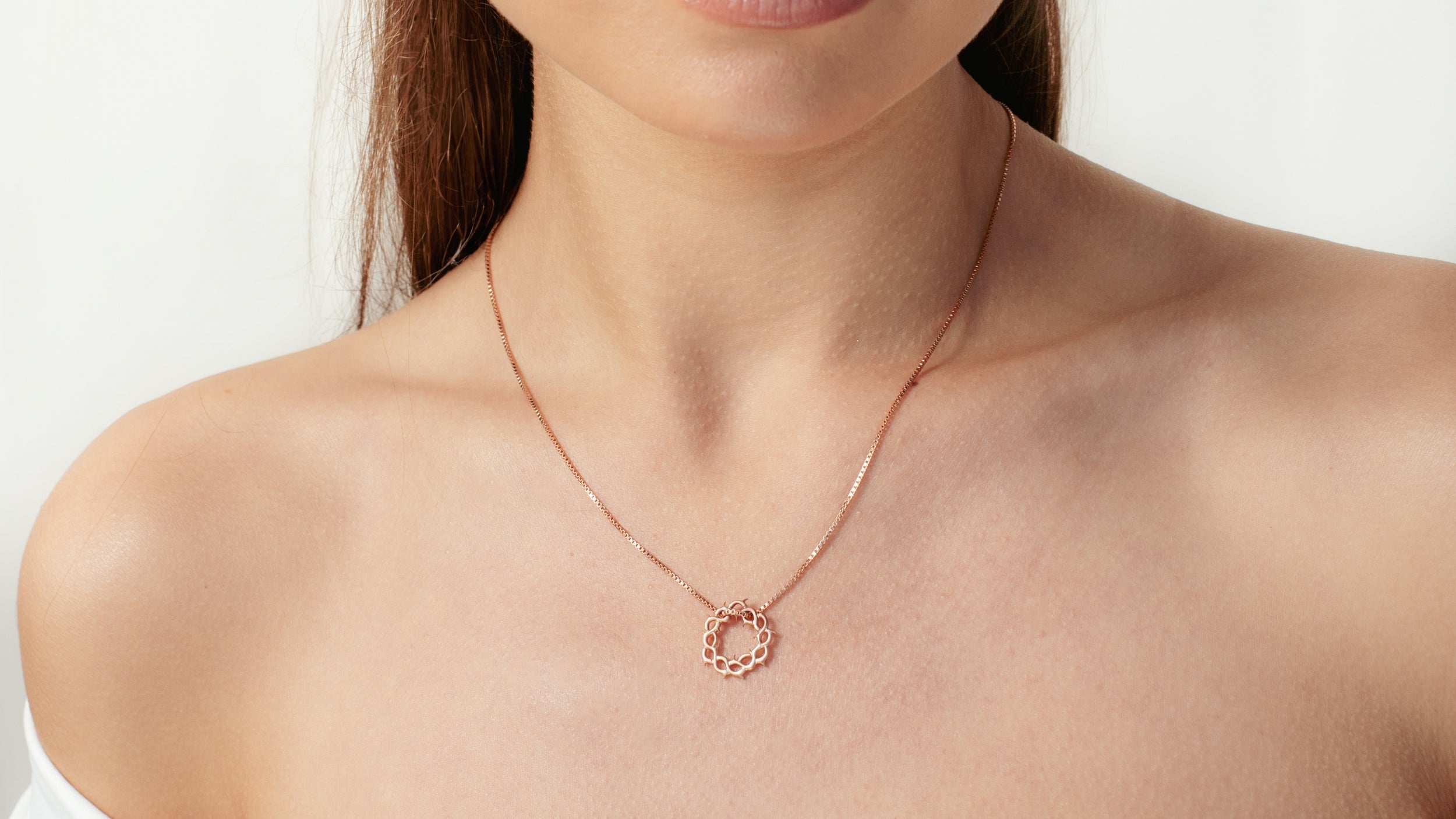 Christian model wearing faith inspired Rizen Jewelry Crown of Thorns Cross Necklace and mini Cross Stud Earring