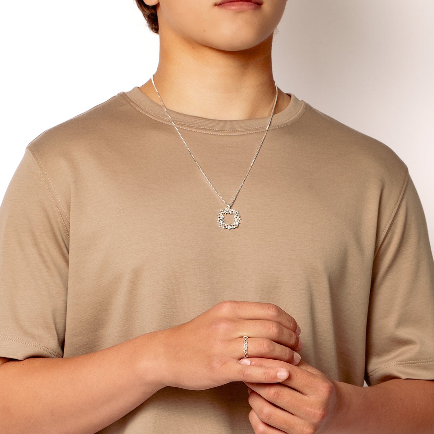 Crown of Thorns Band Ring in sterling silver worn by a male christian jewelry model from the Insignia Collection by Rizen Jewelry.