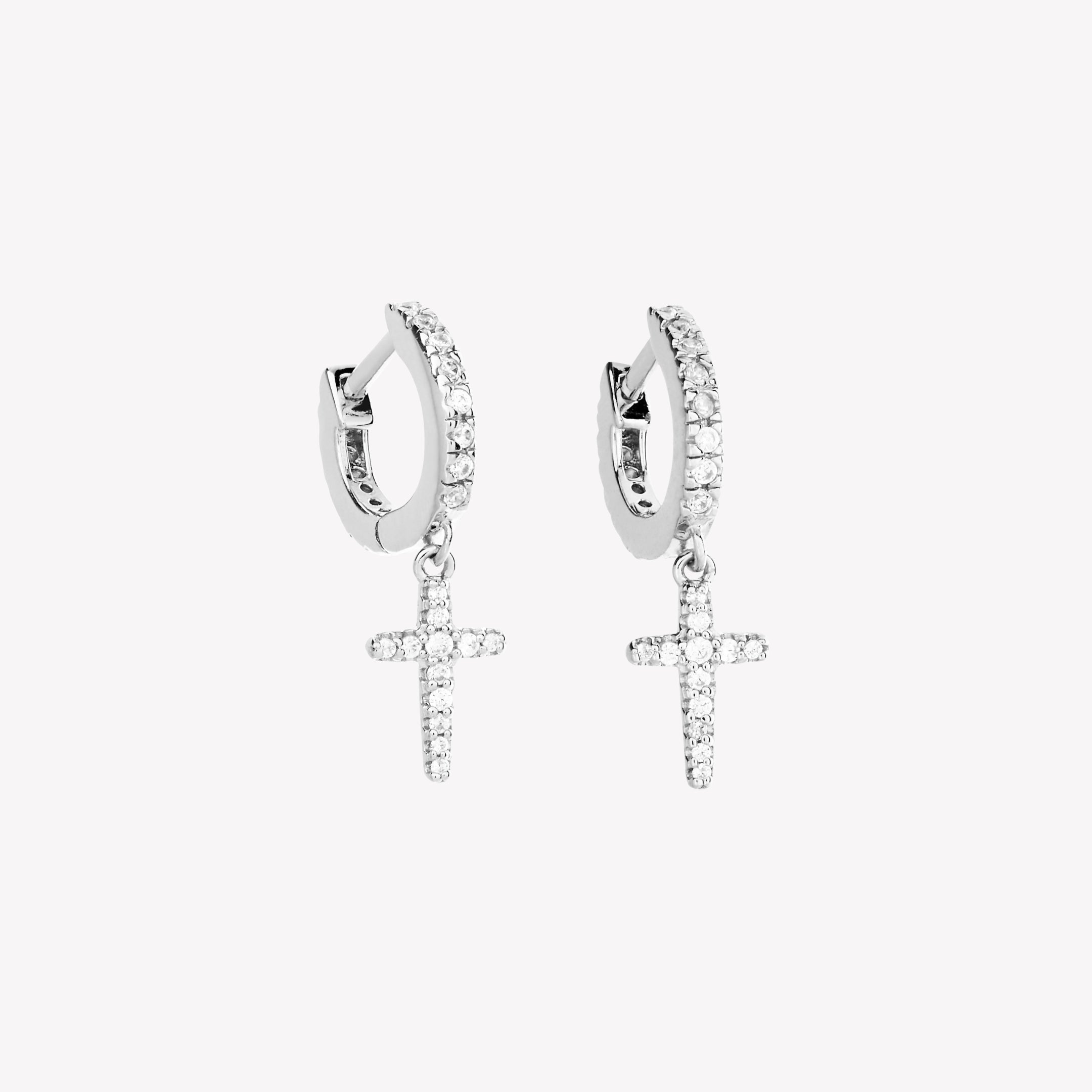 Sterling silver hoop earrings featuring delicate pointed cross charms. These sleek huggie hoops are paved with 24 micro-set zirconias throughout. Comfortable hinge closure. From the Calvary Collection by Rizen Jewelry.