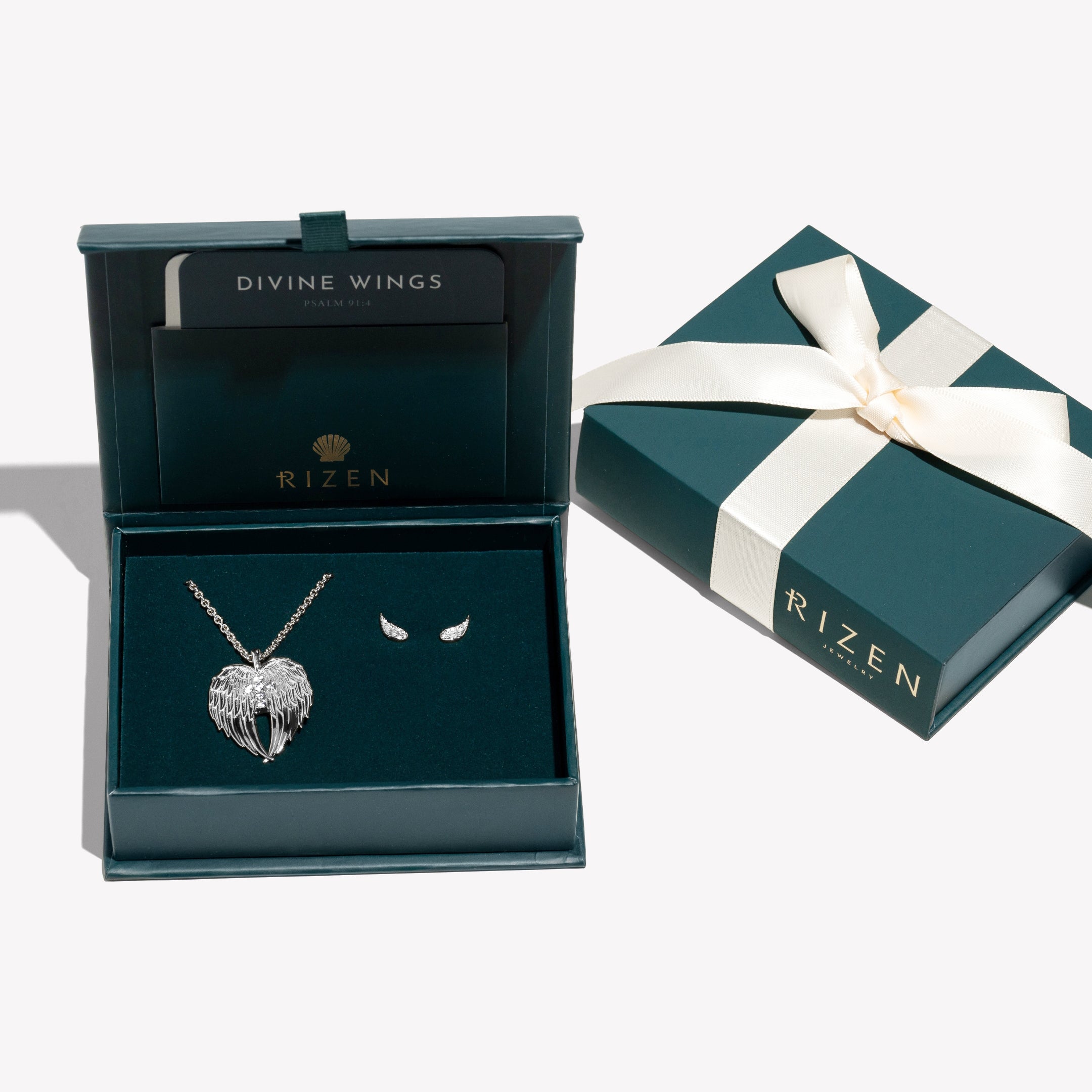 Sterling silver Divine Wings Jewelry Set featuring the angel wing necklace with a sparkly cross and the matching Divine Wing Earrings. Ready to Gift in a Rizen Jewelry Wrapped Box with a keepsake devotion.