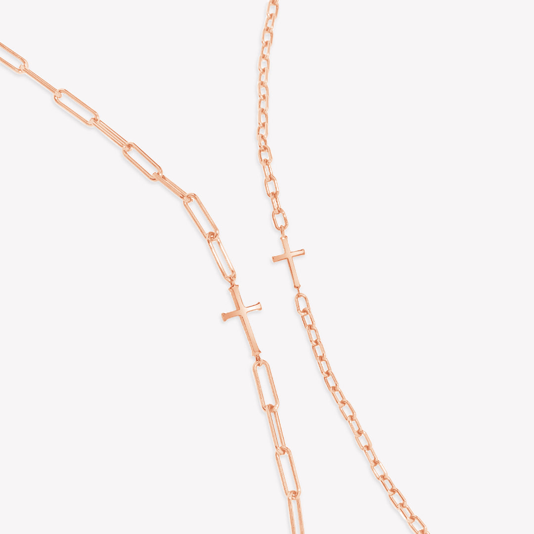 Mini Chain Breaker Cross Necklace in 18k rose gold vermeil from the calvary collection by Rizen Jewelry next to the original Chain Breaker Cross Necklace on the left.