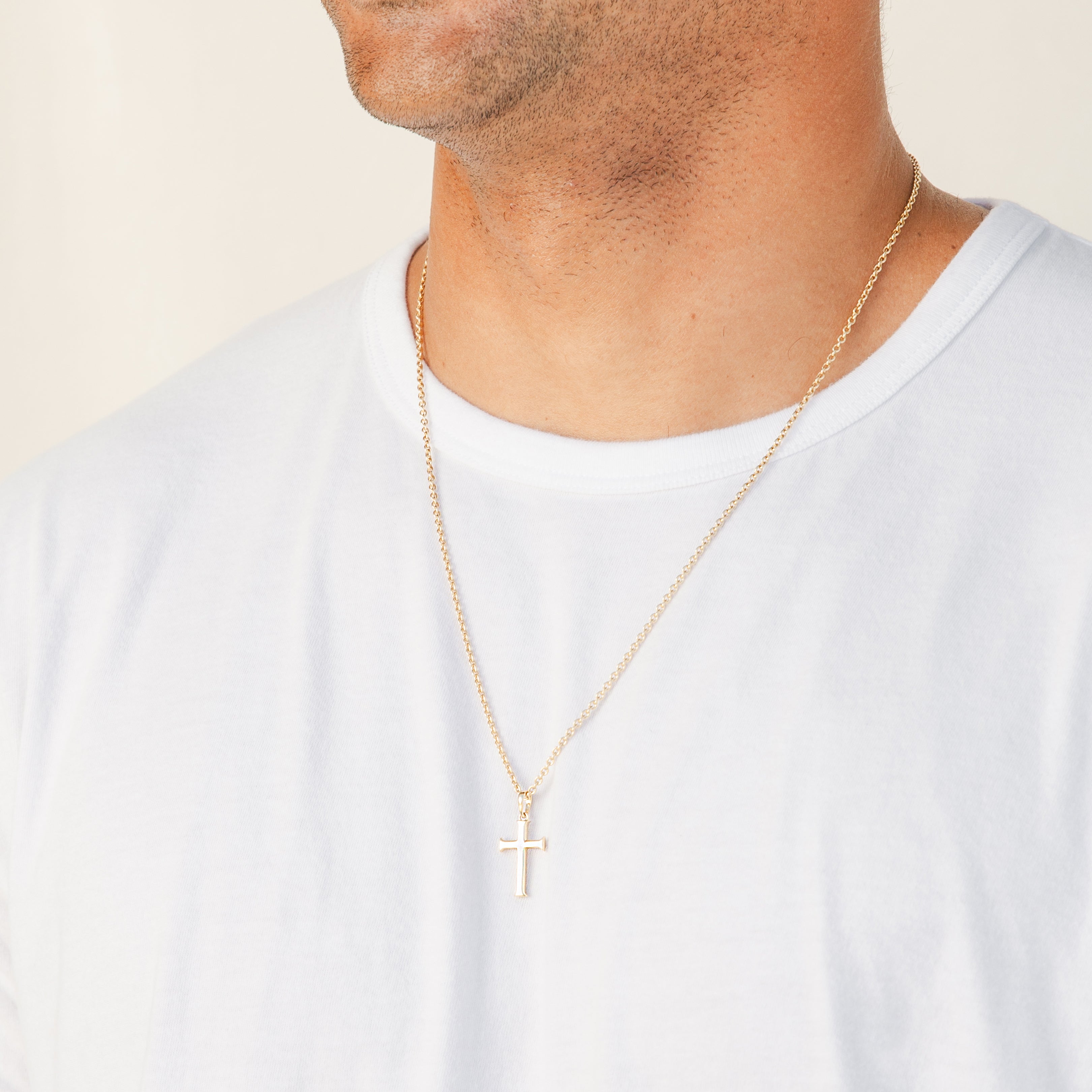 Christian Male Model wearing Rizen Jewelry Large Cross Pendant unisex necklace in 18k yellow gold vermeil that hangs from a long fully adjustable cable chain.