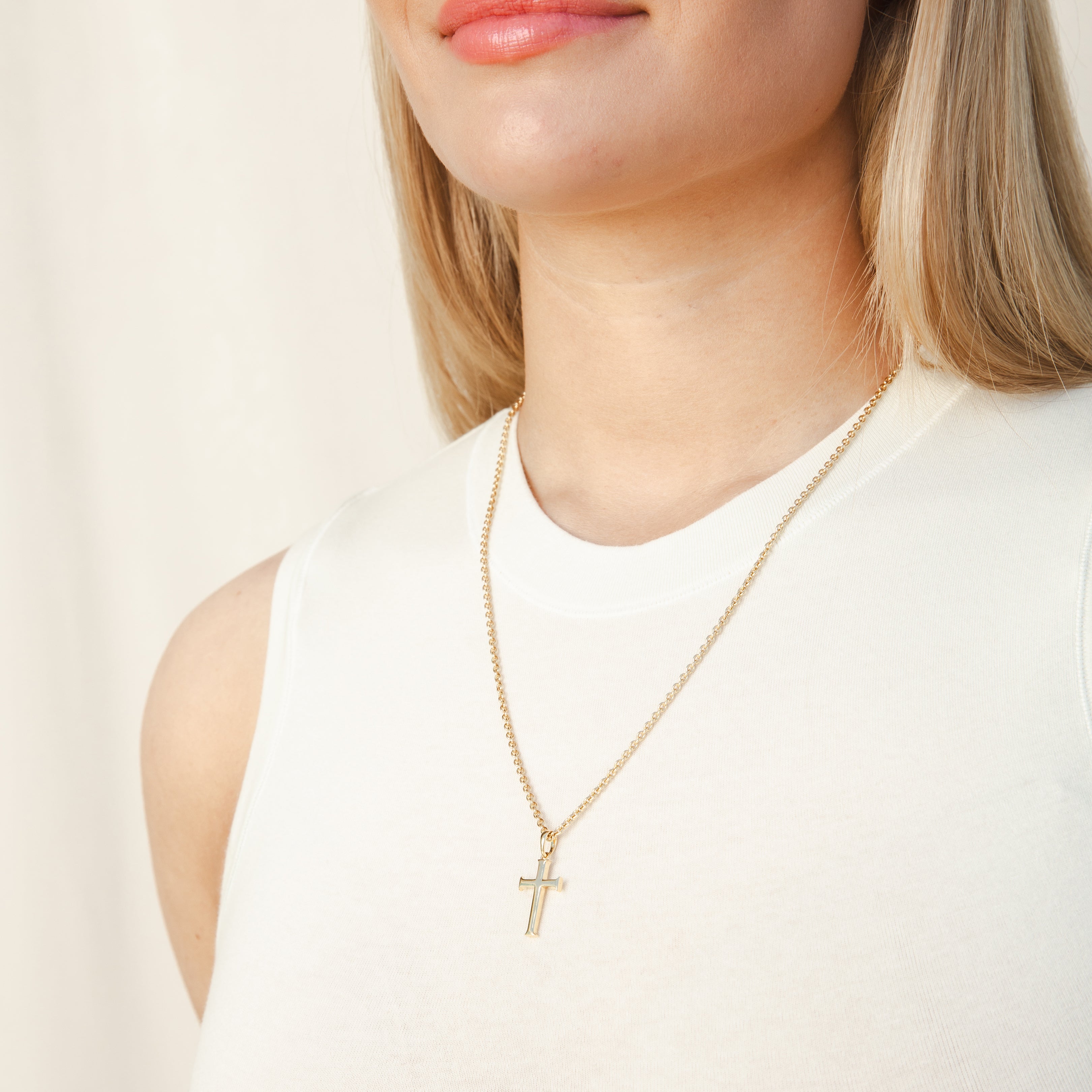 Christian Female Model wearing Rizen Jewelry Large Cross Pendant unisex necklace in 18k yellow gold vermeil. That hangs elegantly from a long fully adjustable cable chain.