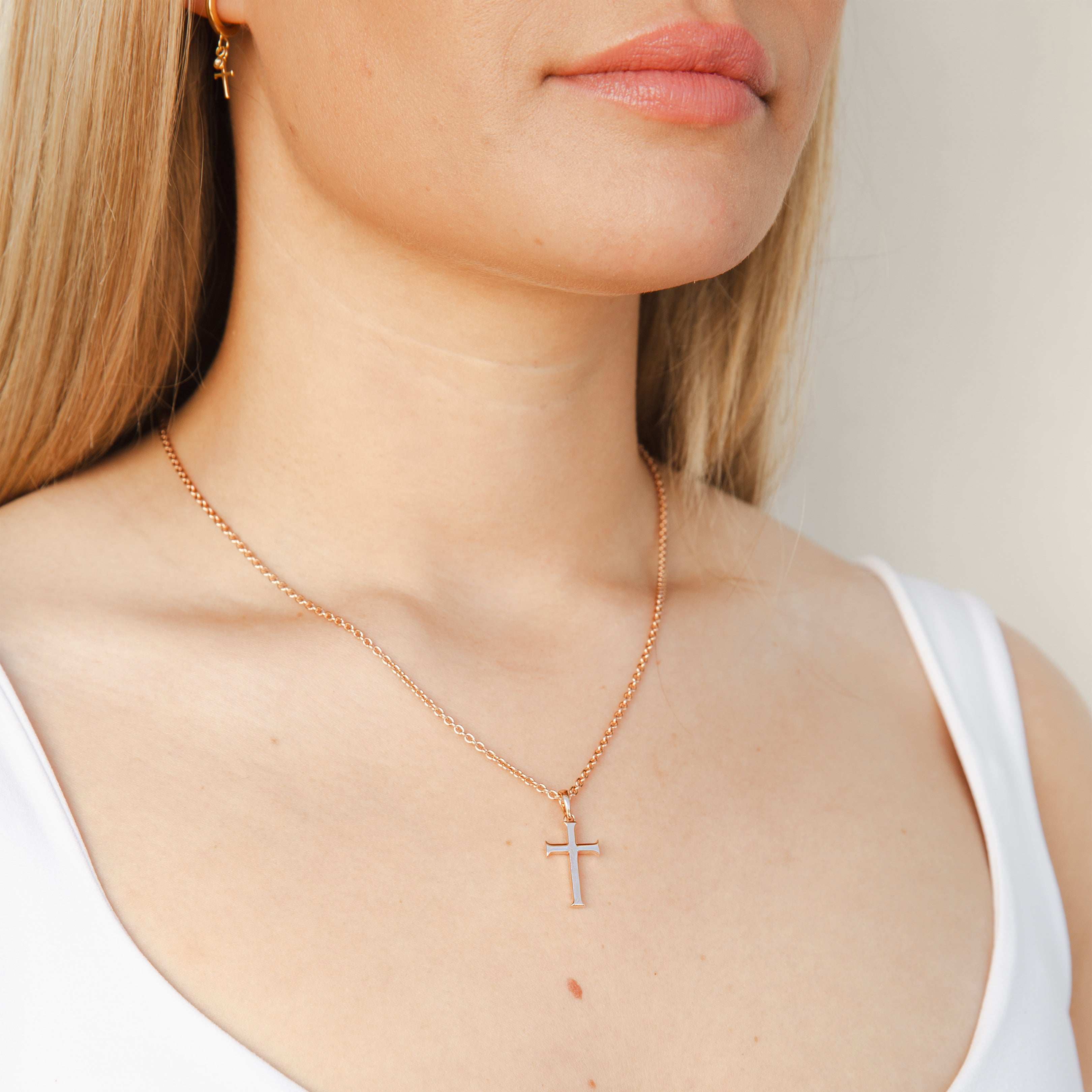 Christian woman wearing Rizen Jewelry Large Cross Pendant in 18k rose gold vermeil with a long fully adjustable cable chain..