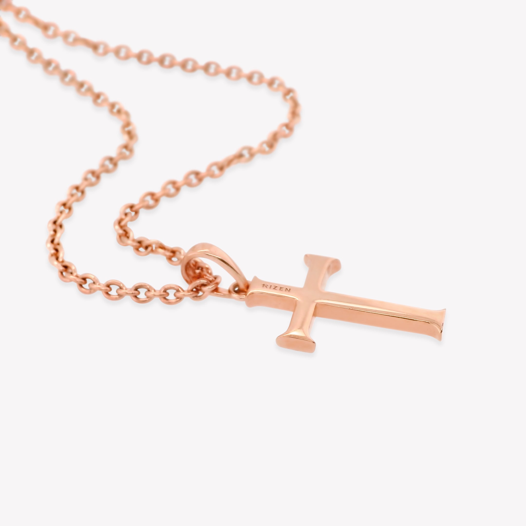 back side of  Rizen Jewelry Large Cross Pendant in 18k rose gold vermeil hangs from a long fully adjustable cable chain that is unisex. RIZEN is engraved along the top of the cross.