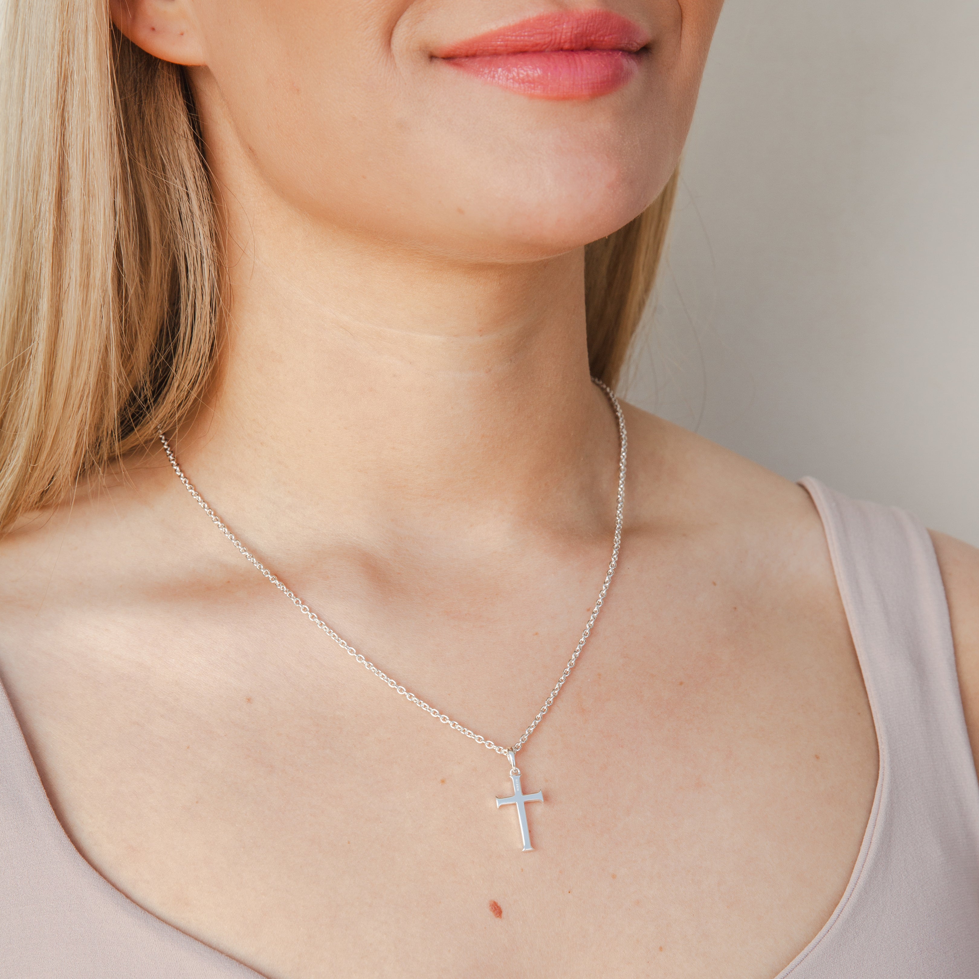 Female Christian Model wearing Rizen Jewelry Large Cross Pendant necklace in sterling silver that hangs from a long fully adjustable cable chain.