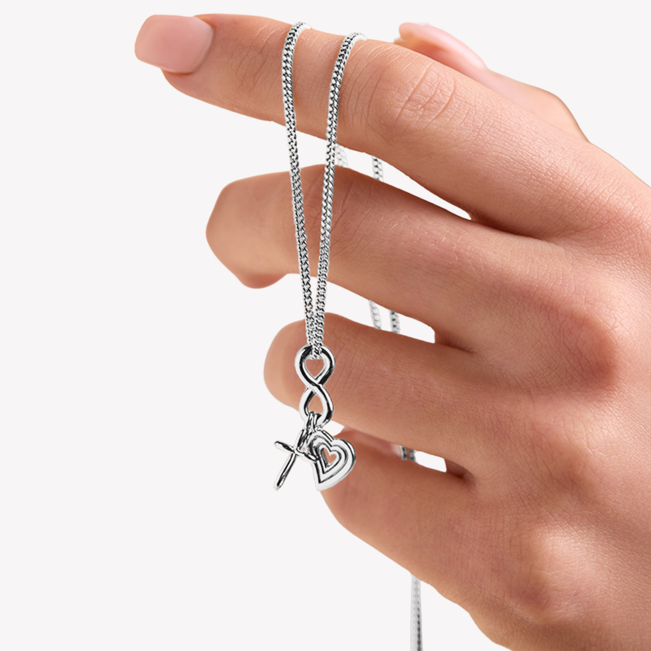 aith Hope Love Necklace featuring 3 charm pendants: an infinite cross for faith, an infinity for hope, and a radiating open heart for love set on a sterling silver cable chain held by a Rizen Jewelry female model