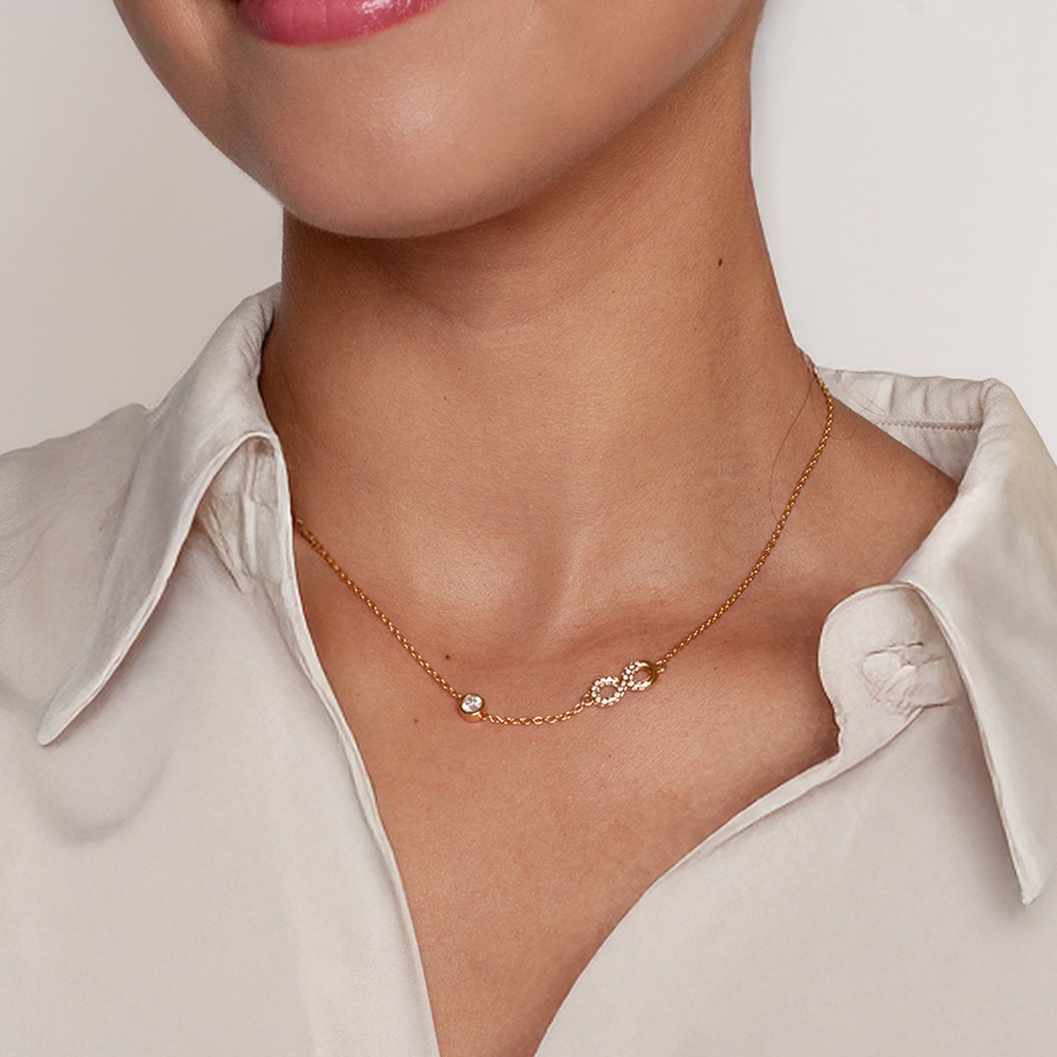 radiant 18k gold vermeil Infinite Hope necklace showcases a pavé zirconia ichthys nestled within an infinity pendant, elegantly crowned by a 5mm solitaire centerpiece worn  by Rizen female model.