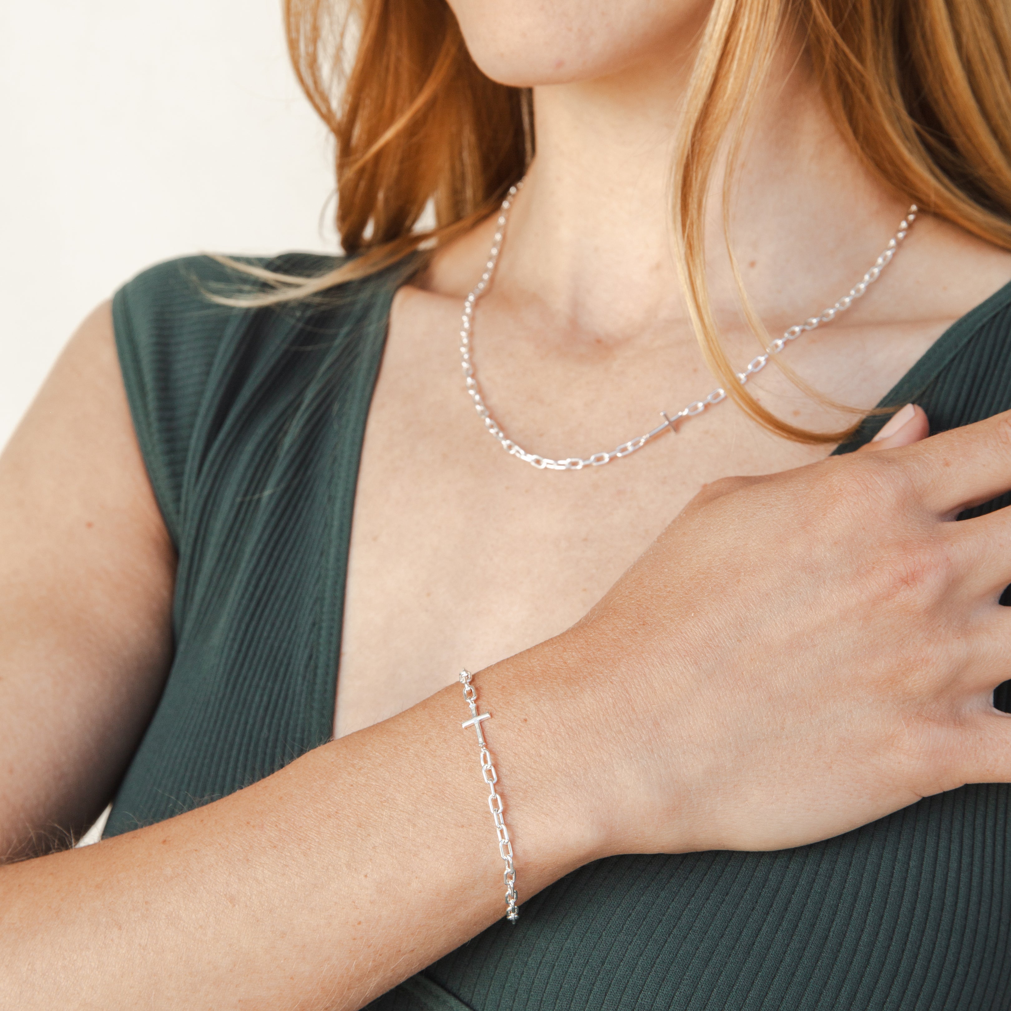 Mini Chain Breaker Cross Bracelet in sterling silverl from the calvary collection by Rizen Jewelry worn by a Christian model who is also wearing the matching necklace.