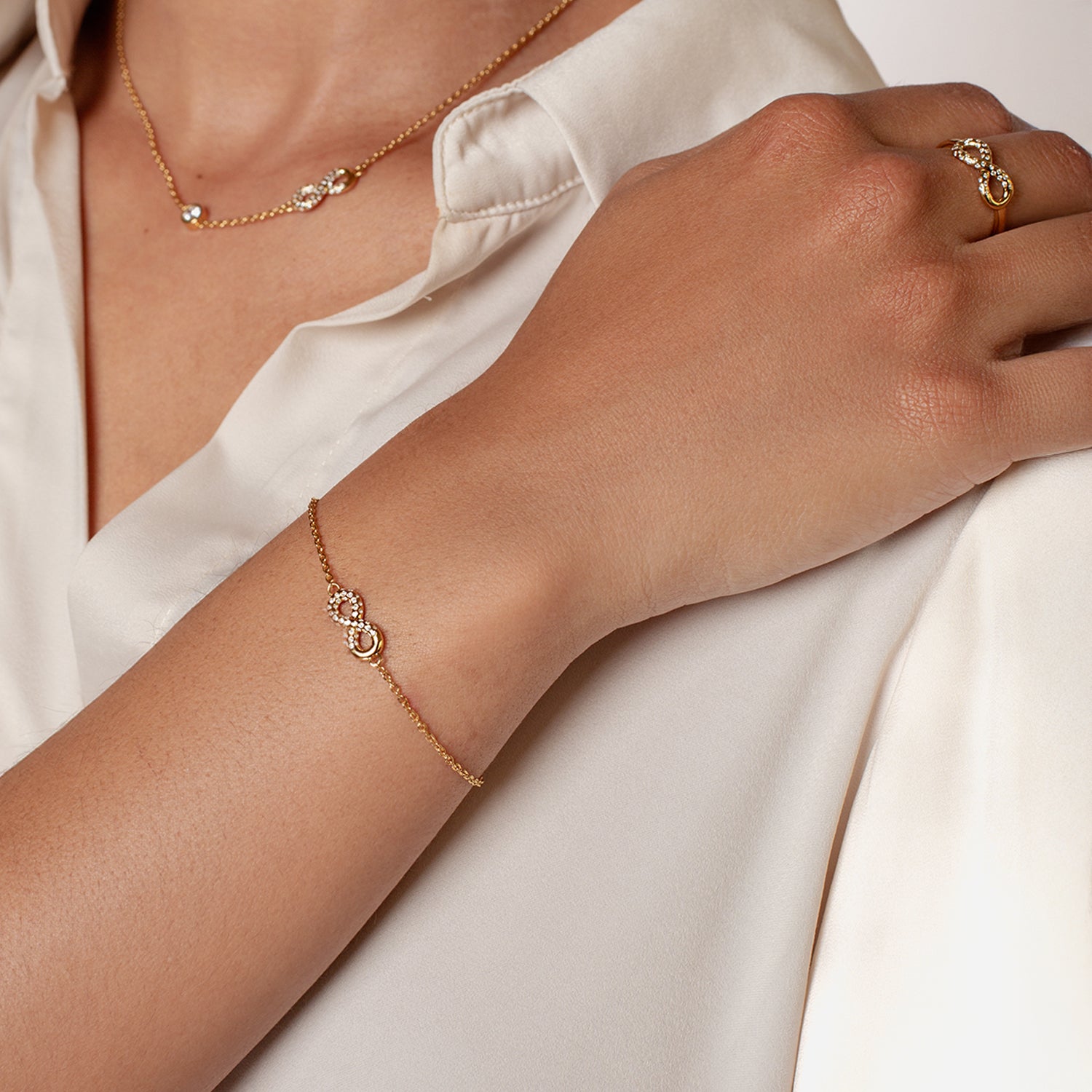 18k gold vermeil Infinite Hope Statement Ring showcases a pavé zirconia ichthys nestled within the infinity symbol pairs beautifully with the matching bracelet and necklace worn on a Rizen Jewelry ambassador.