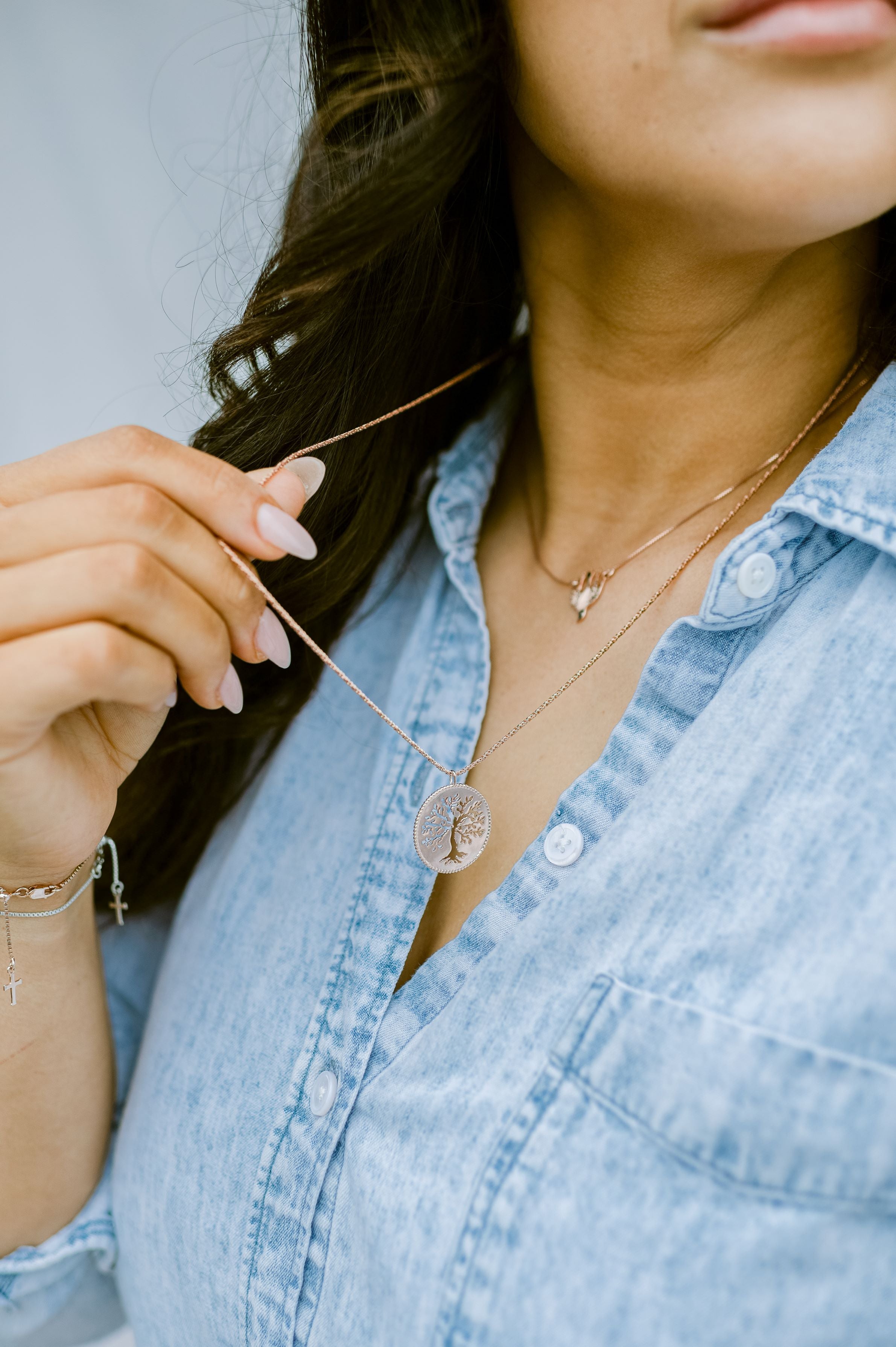 Designer Christian jewelry model wearing Rizen Jewelry gold Olive Tree and chispa de la Dove necklaces.