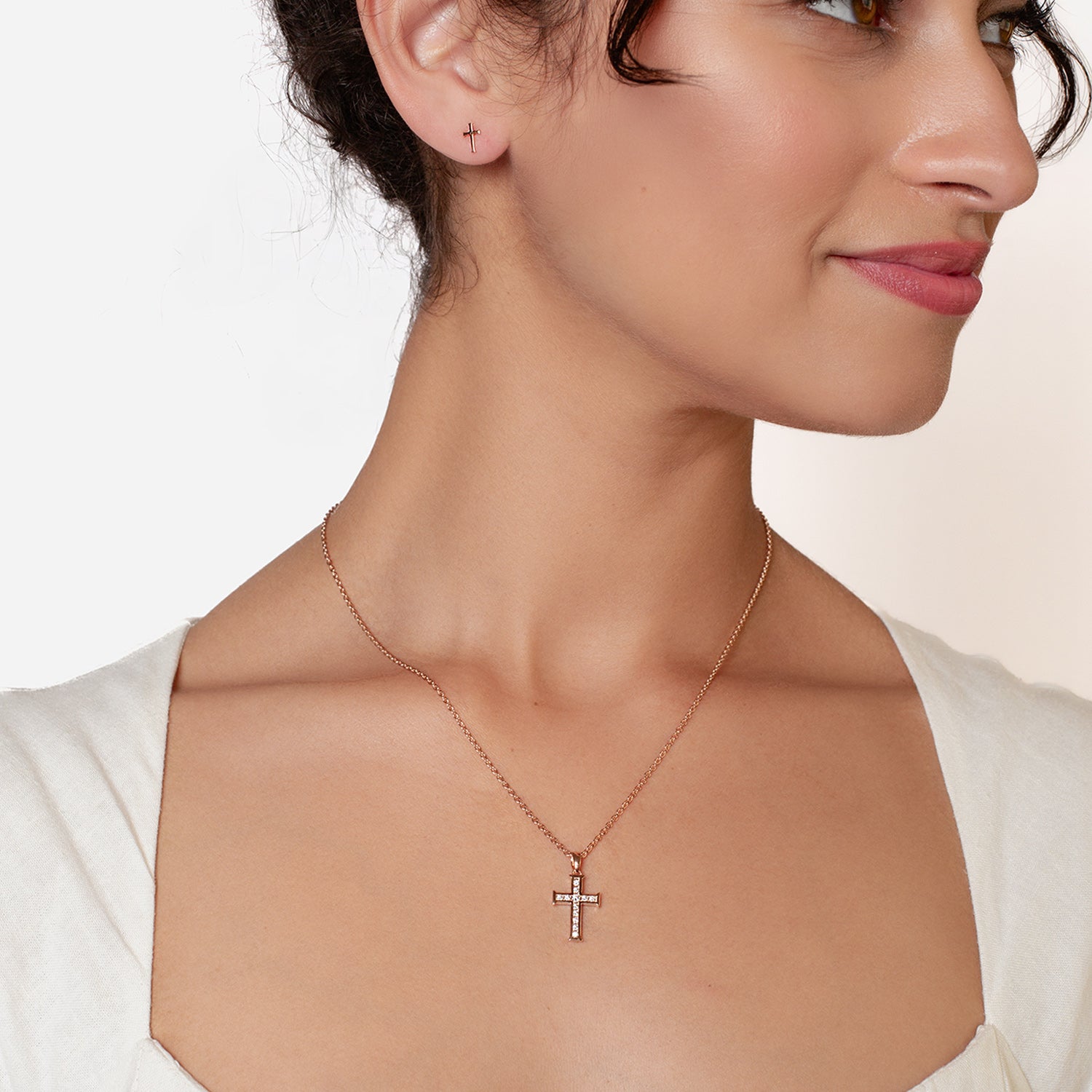 18k rose gold vermeil luminous cross pendant necklace featuring 12 sparkling cubic zirconia channel set on an adjustable 20" cable chain by Rizen Jewelry worn by Christian woman.