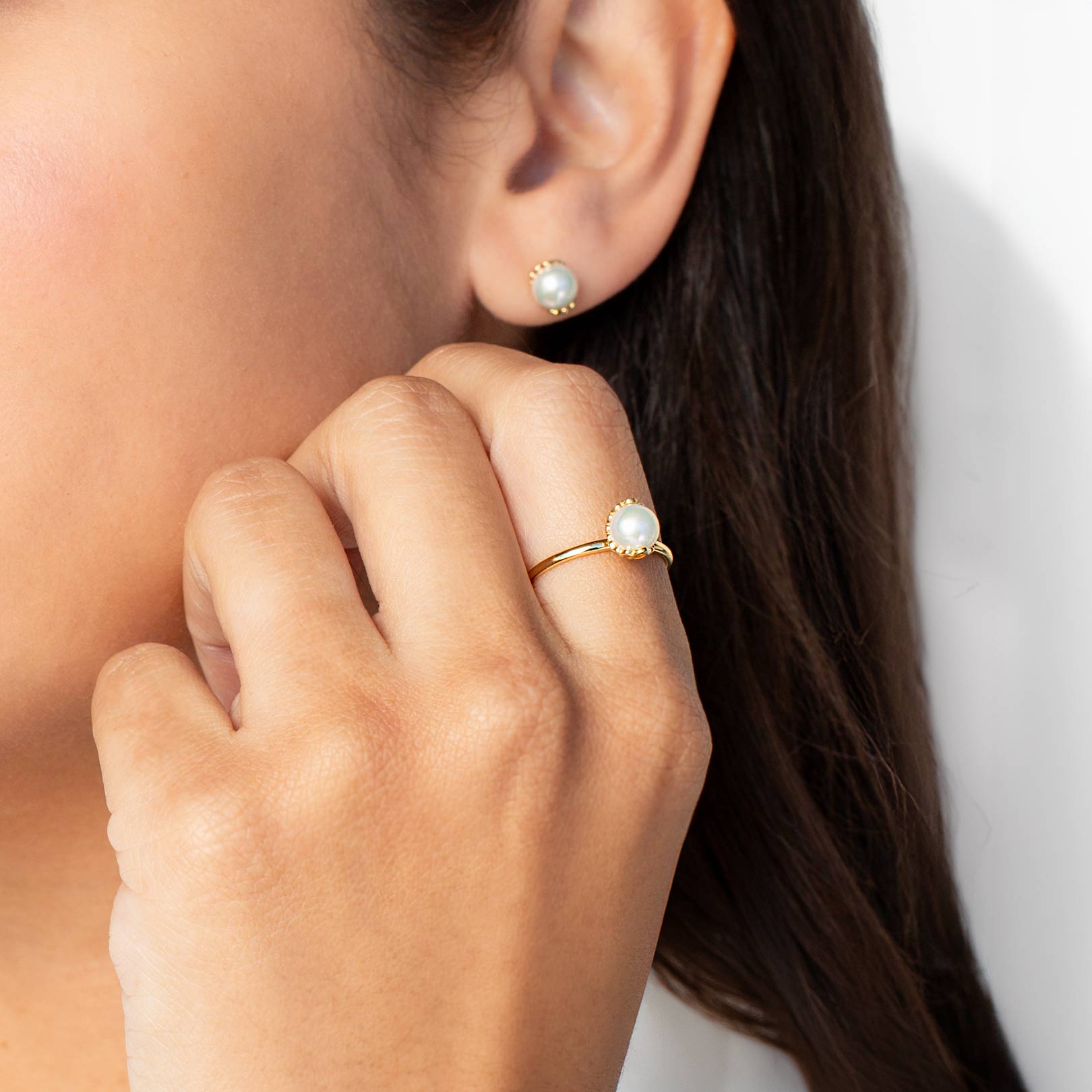 Close up of a christian woman wearing the 18k gold vermeil Shell Encased Pearl Ring and Earring from the Becoming Collection by Rizen Jewelry.