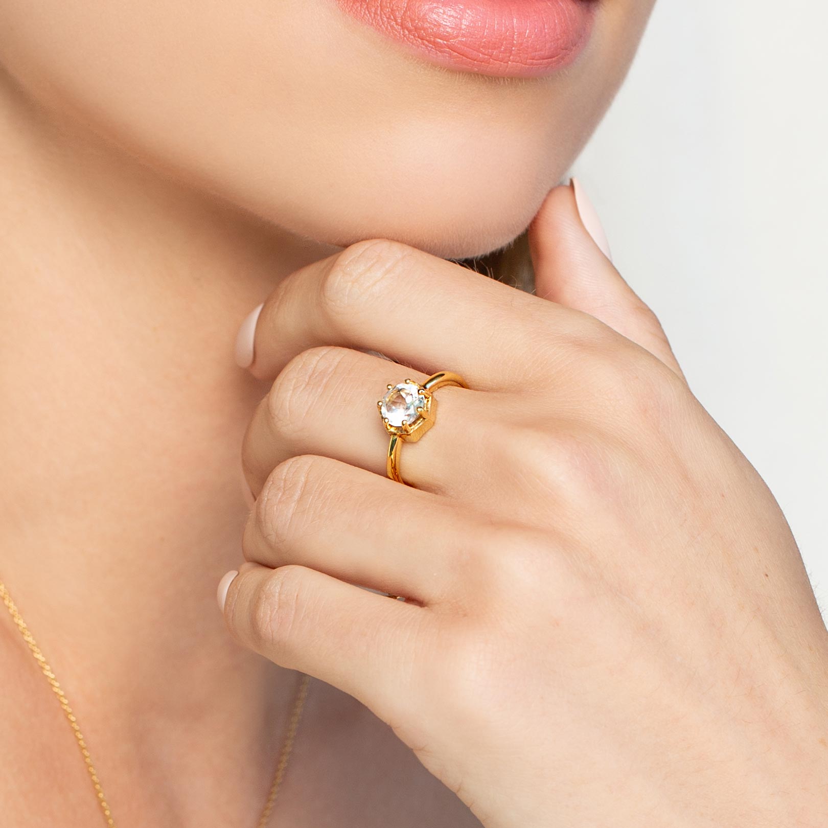 Close up of a christian woman wearing 18K gold vermeil white topaz Ebenezer Solitaire Ring from the Chispa Collection by Rizen Jewelry.