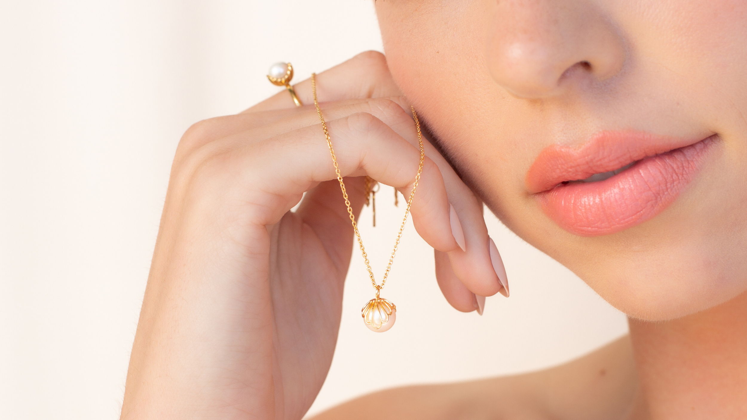 Rizen Jewelry Becoming Collection featuring the Pearl encased shell necklace and ring on a Christian model.