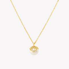 Rizen Jewelry shell encased pearl necklace in gold vermeil from the Becoming Collection.
