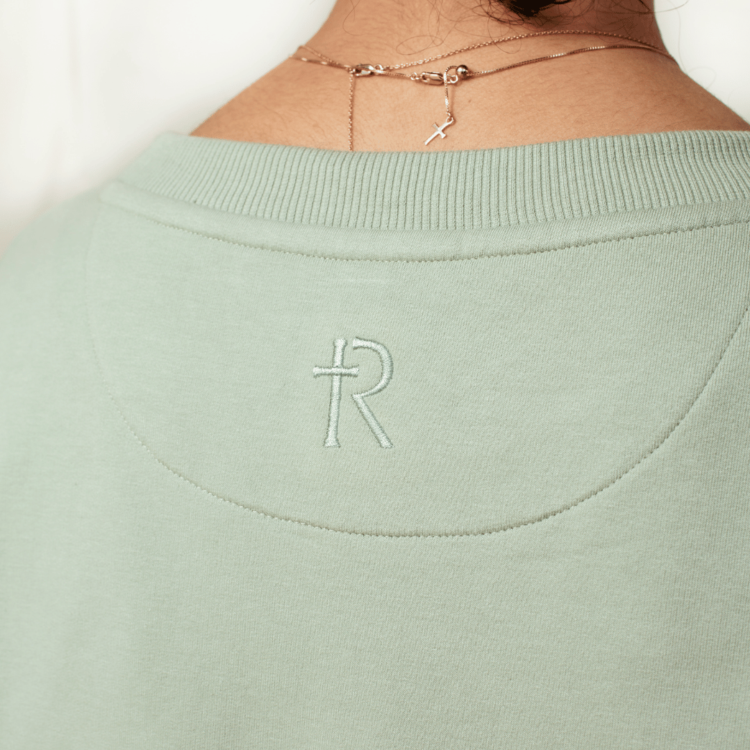 Close up of RIZEN logo embroidery on the back of the wave green "Stay Salty. Matthew 5:13" Peruvian cotton crew sweatshirt from the Be The Light Collection by Rizen Jewelry.