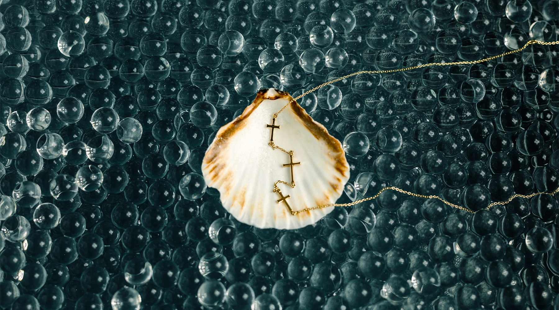 Rizen Jewelry gold vermeil triple cross necklace in a scallop shell