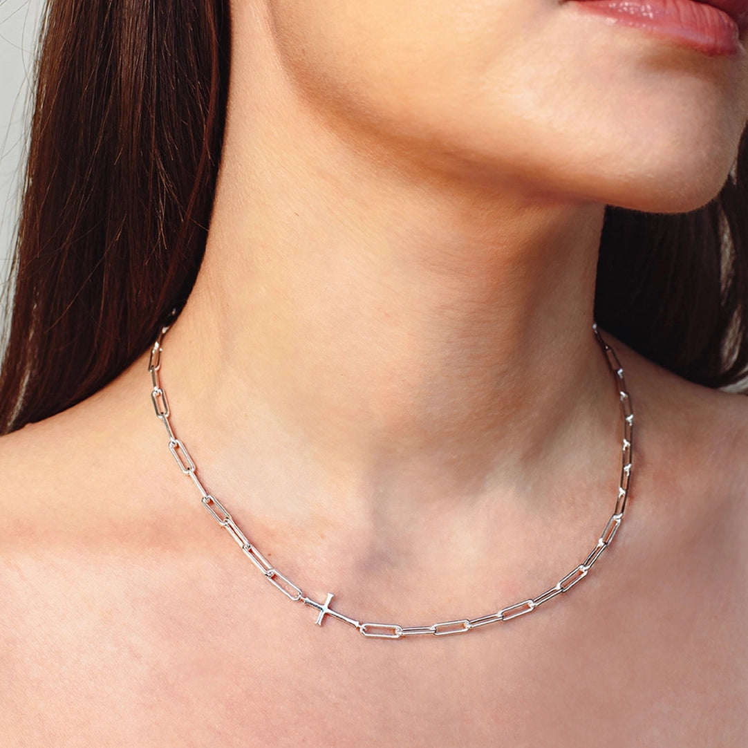 Close up of christian woman wearing chain breaker cross necklace in sterling silver from the Calvary Collection by Rizen Jewelry. 