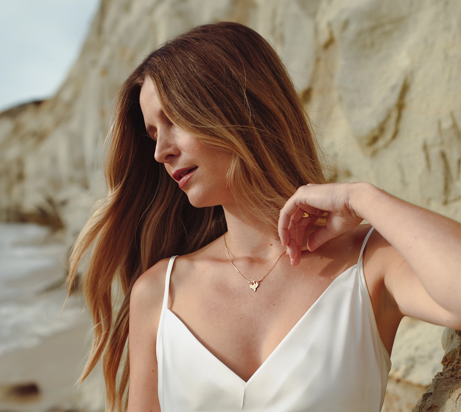 Christian woman wearing the gold Chispa de la Dove Necklace by Rizen Jewelry.