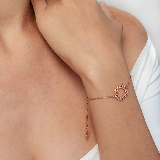 Close up of christian woman wearing the crown of thorns bracelet in 18k rose gold vermeil from the Insignia Collection by Rizen Jewelry. 