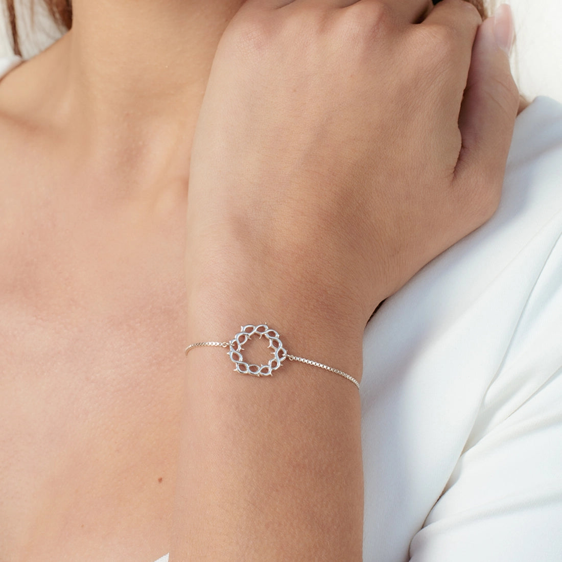 Christian woman wearing silver Crown of Thorns Bracelet from the Insignia Collection by Rizen Jewelry.