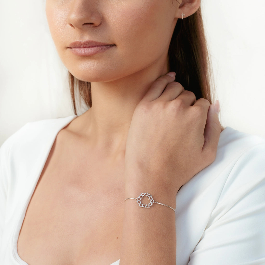Christian woman wearing a sterling silver Crown of Thorns Bracelet from the Insignia Collection by Rizen Jewelry.