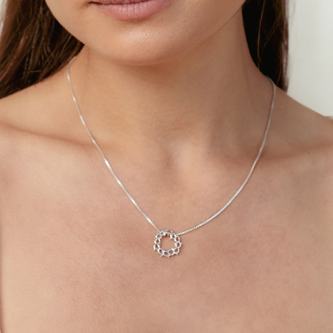 Christian woman wearing silver Crown of Thorns necklace from the Insignia Collection by Rizen Jewelry