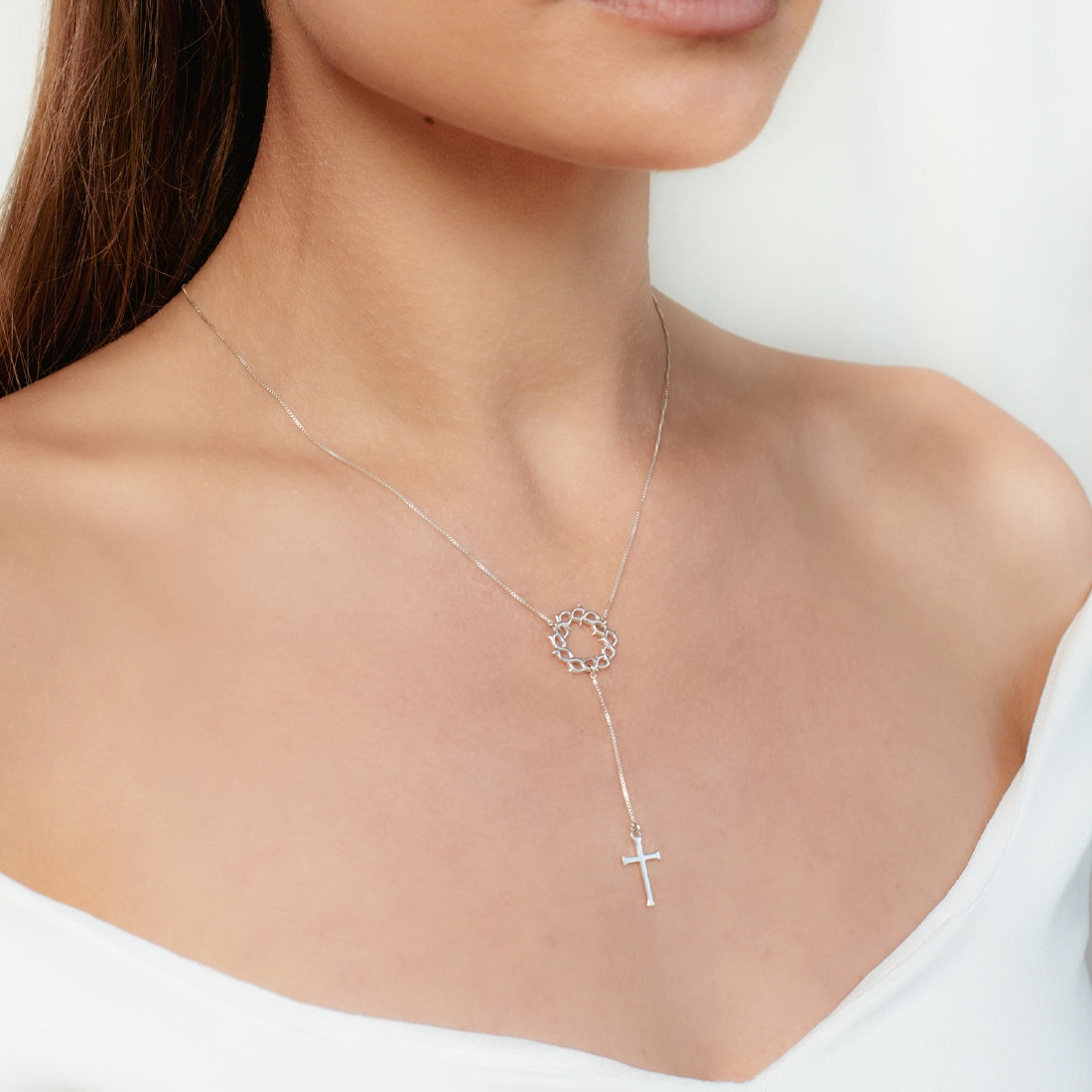 Christian woman wearing the sterling silver Crown of Thorns Y Necklace with cross pendant from the Insignia Collection by Rizen Jewelry.