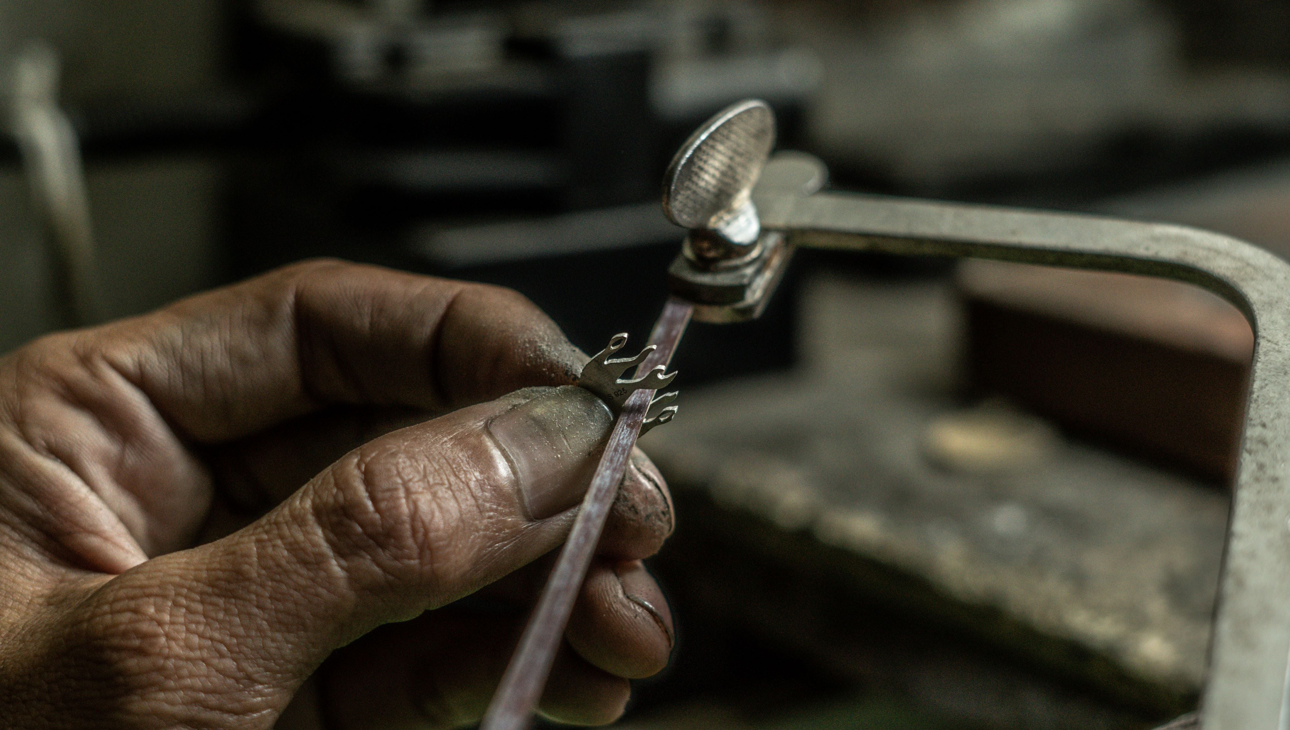 Rizen Jewelry artisan hand polishing dove pendant
