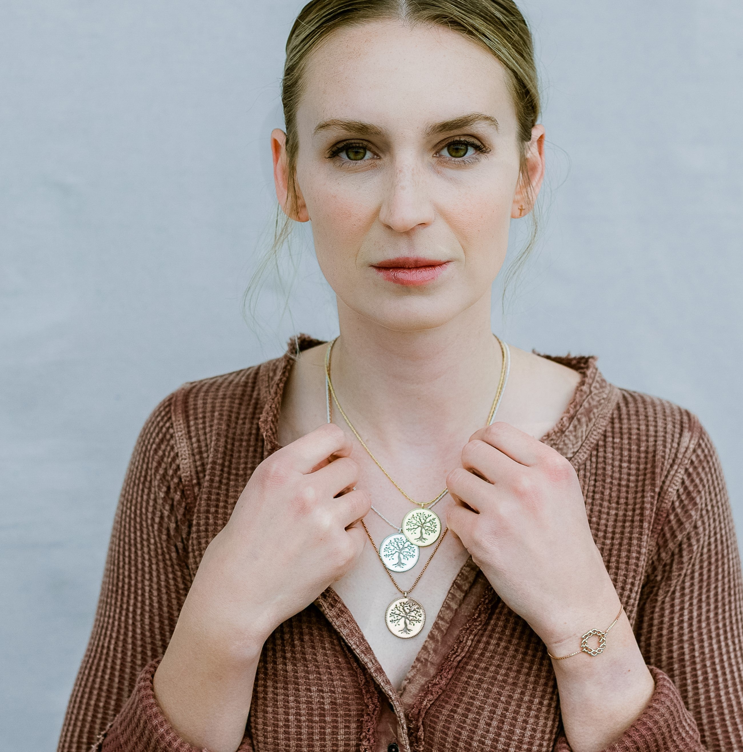 Designer christian jewelry model wearing 3 rooted olive tree necklaces in sterling silver, rose gold and gold vermeil.