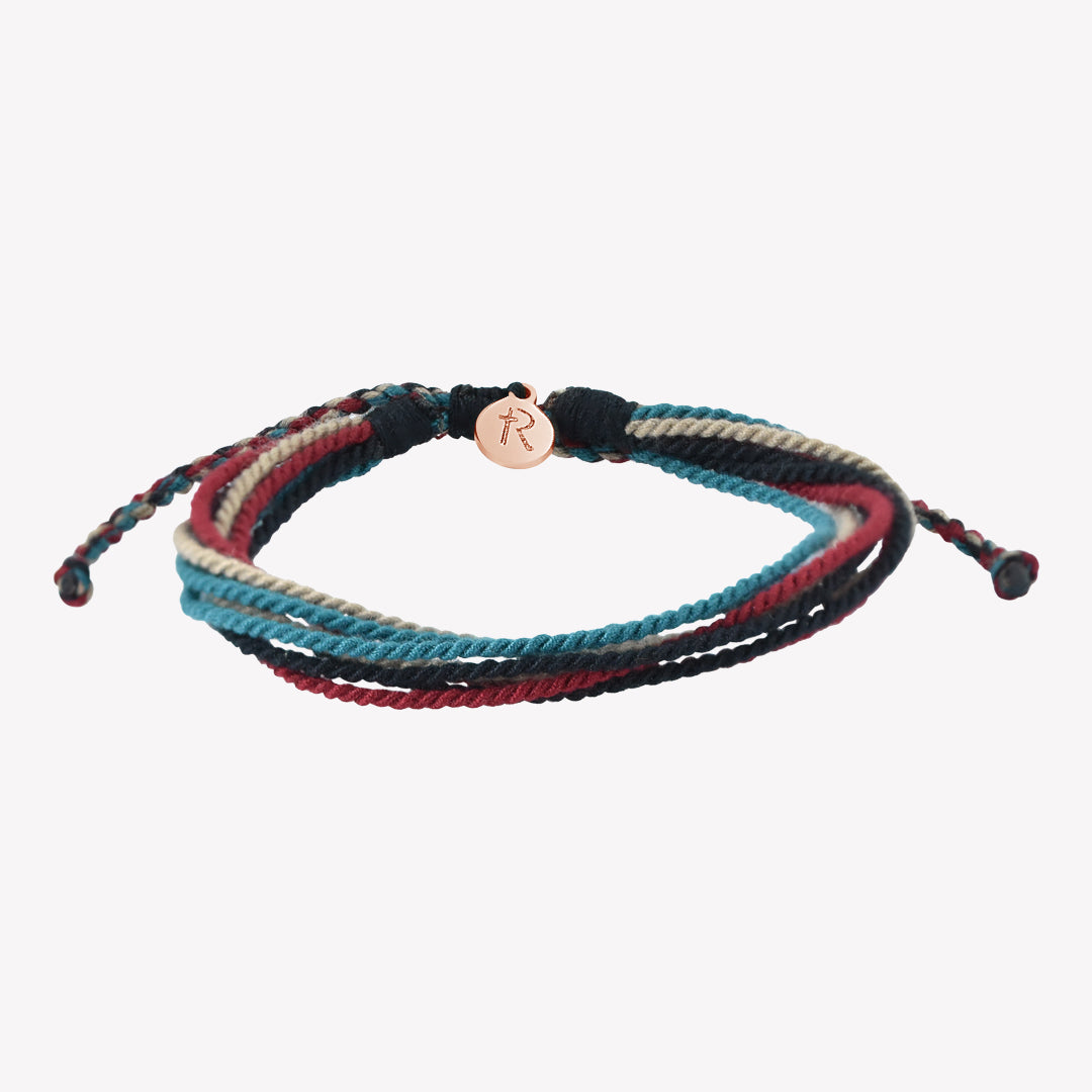 Rizen Jewelry Be Magnified Faithful multicord macrame bracelet. Cotton cords in black, garnet red, azure blue, and khaki with rose gold tag. Made 4 Ministries Collection.