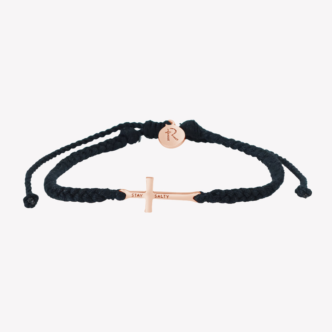 Christian Rose Gold cross bracelet engraved "STAY SALTY" hand braided black cotton cords with round Rizen Jewelry Made 4 Ministries tag.