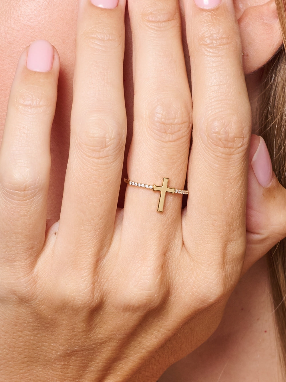 female model wearing the Luminous cross pave ring in 18k gold plated from the Calvary collection. A wonderful Christian Jewelry Gift by Rizen Jewelry.