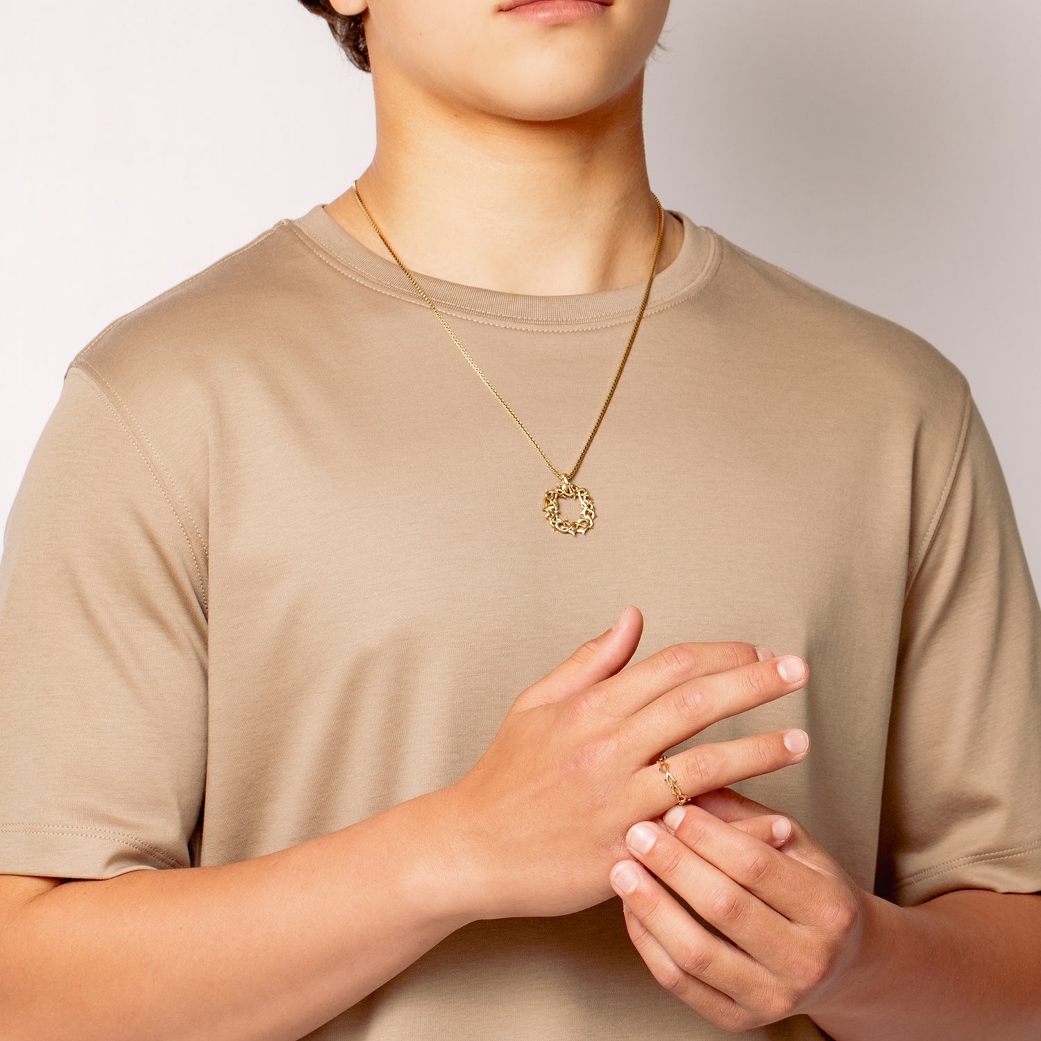 Male Christian jewelry model wears tthe large Crown of Thorns Pendant Necklace and Crown of Thorns band ring from the Insignia Collection by Rizen Jewelry