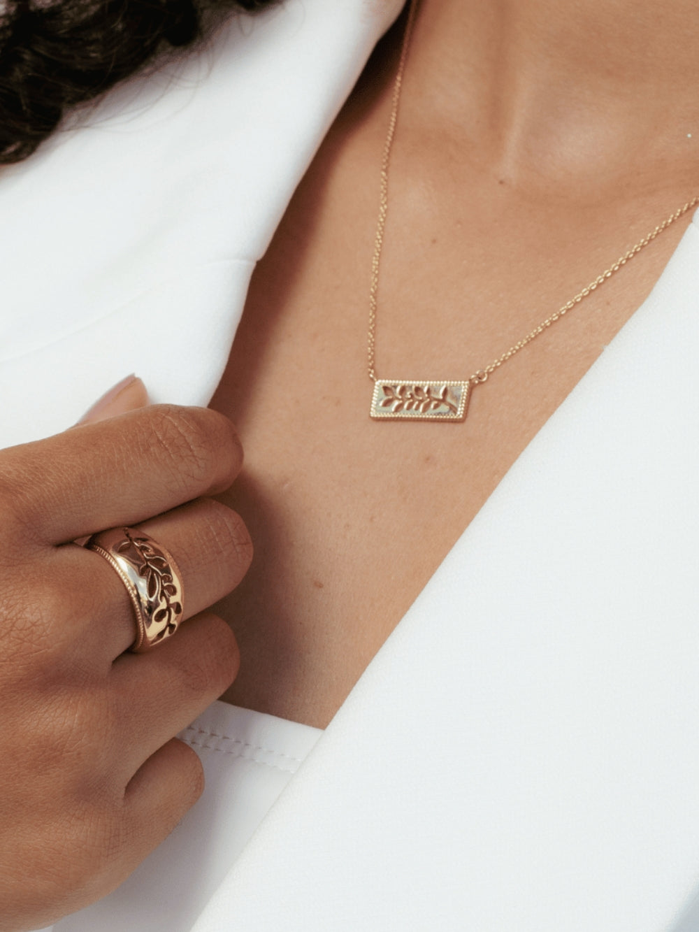 Women's Christian jewelry model is wearing the Olive branch ring in 18k gold plated alongside a necklace from the Rooted collection.  Inspirational gift for any occasion by Rizen Jewelry.
