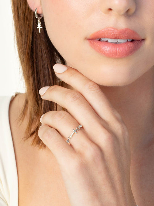 Women's Christian jewelry model is wearing the Mini chain breaker cross ring in sterling silver alongside earrings from the Calvary collection.  A timeless baptism gift by Rizen Jewelry.
