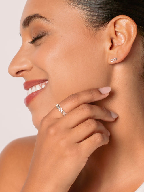 Women's Christian jewelry model is wearing the Infinite hope band ring in sterling silver alongside earrings from the Infinite Grace collection.  Inspirational gift for any occasion by Rizen Jewelry.