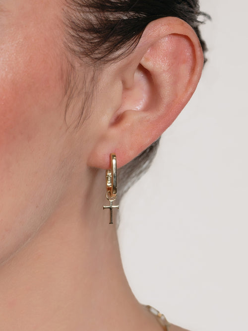 Woman's Christian jewelry model wearing the chain breaker cross hoop earring by Rizen Jewelry. 