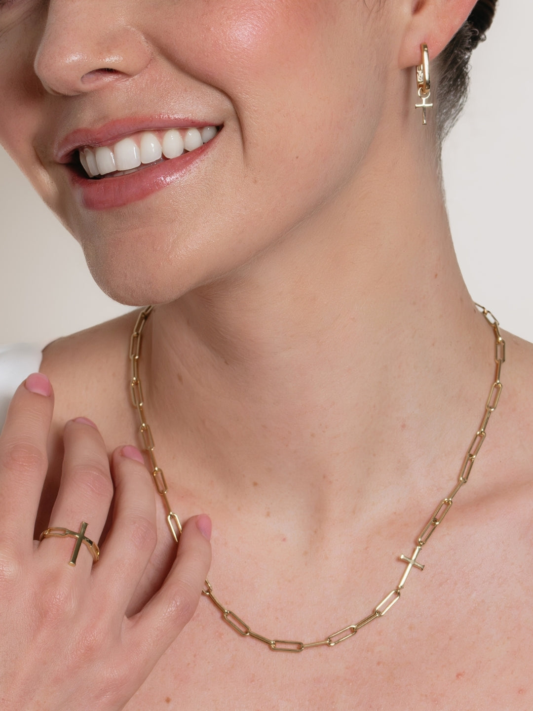 Women's Christian Jewelry model wearing the gold U-Hoop train breaker cross earring by Rizen Jewelry. 