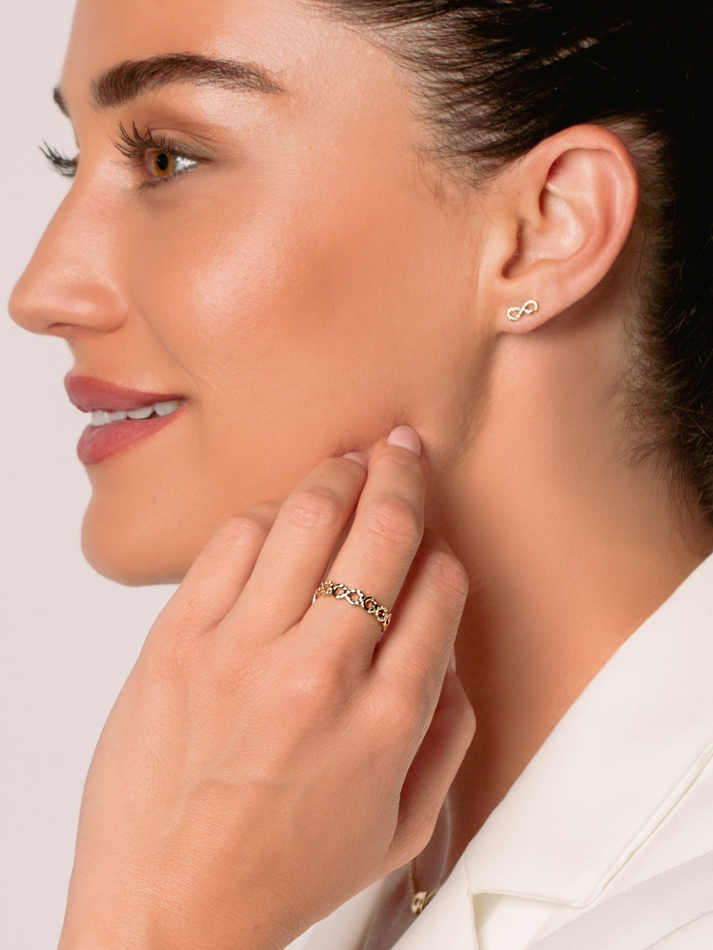 Women's Christian jewelry model is wearing the Infinite hope stud earrings in 18k gold plated alongside a ring from the Infinite Grace collection.  Inspirational gift for any occasion by Rizen Jewelry.
