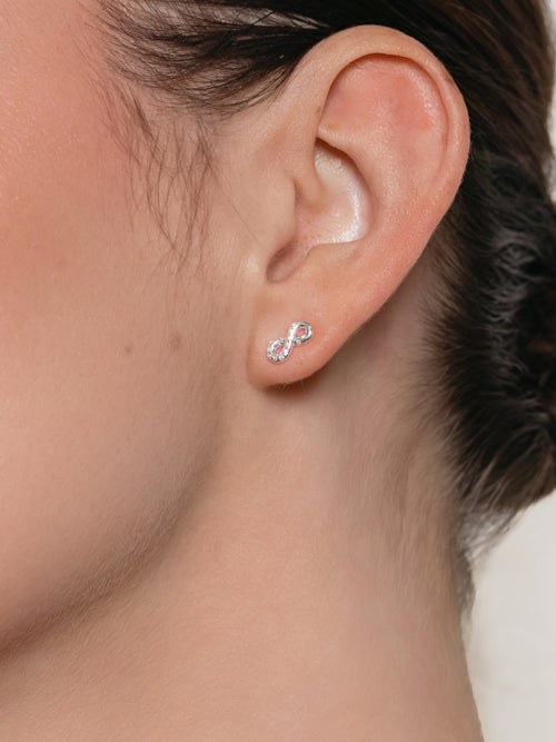 Women's Christian jewelry model is wearing the Infinite hope stud earrings in sterling silver from the Infinite Grace collection. Inspirational gift for any occasion by Rizen Jewelry.