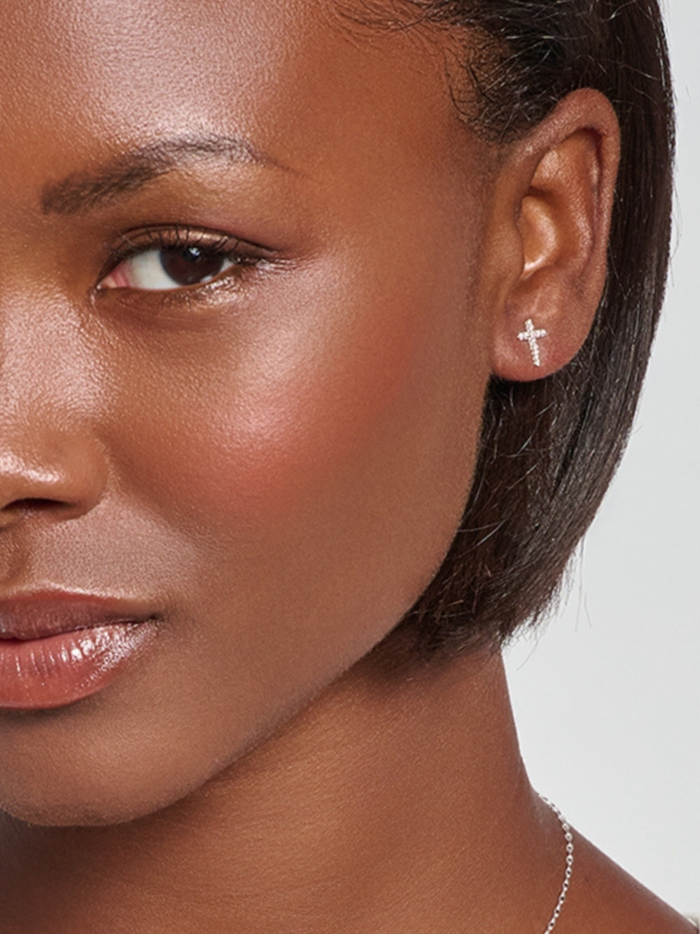 Model wearing the Luminous Cross Pavé Stud Earrings, delicate silver cross studs that shine with faith, designed by Rizen Jewelry. 