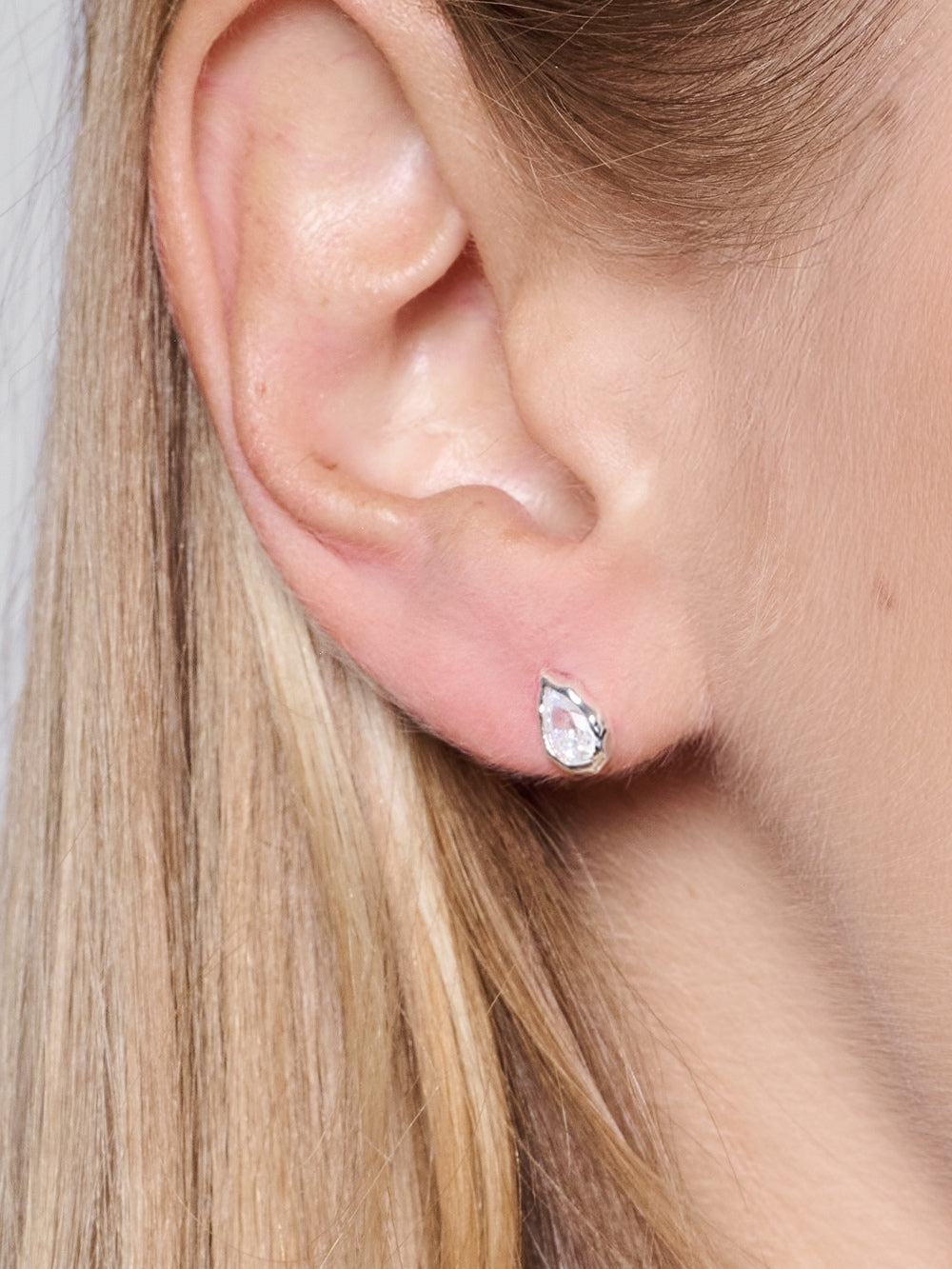  Christian woman wearing the Delicate Solace Teardrop Stud earrings designed by Rizen Jewelry. 