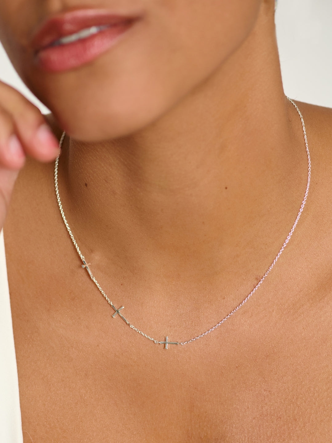 Woman's Christian jewelry model wearing the Calvary Three Sideways Cross Necklace in Sterling Silver by Rizen Jewelry 