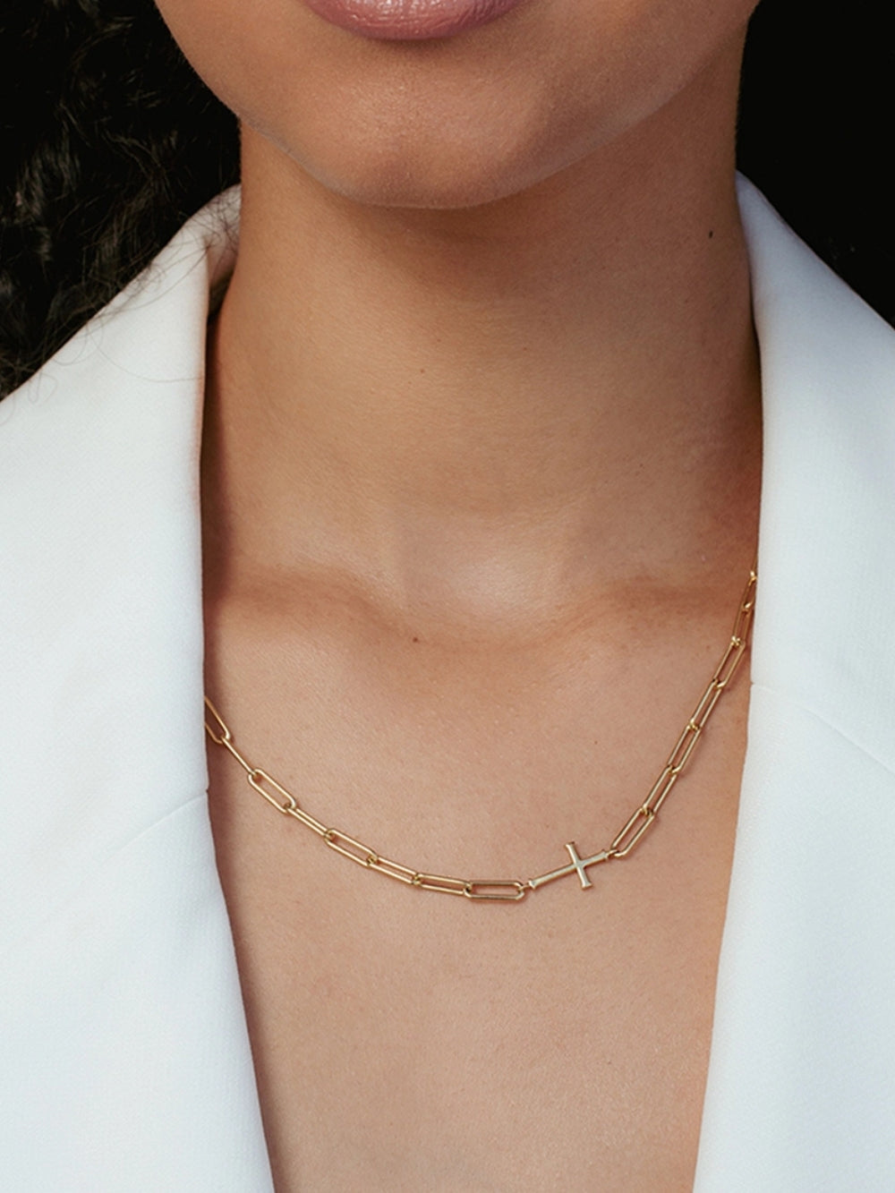 A Christian woman wearing the Chain Breaker necklace in 18k gold plated from the Calvary collection by Rizen Jewelry.