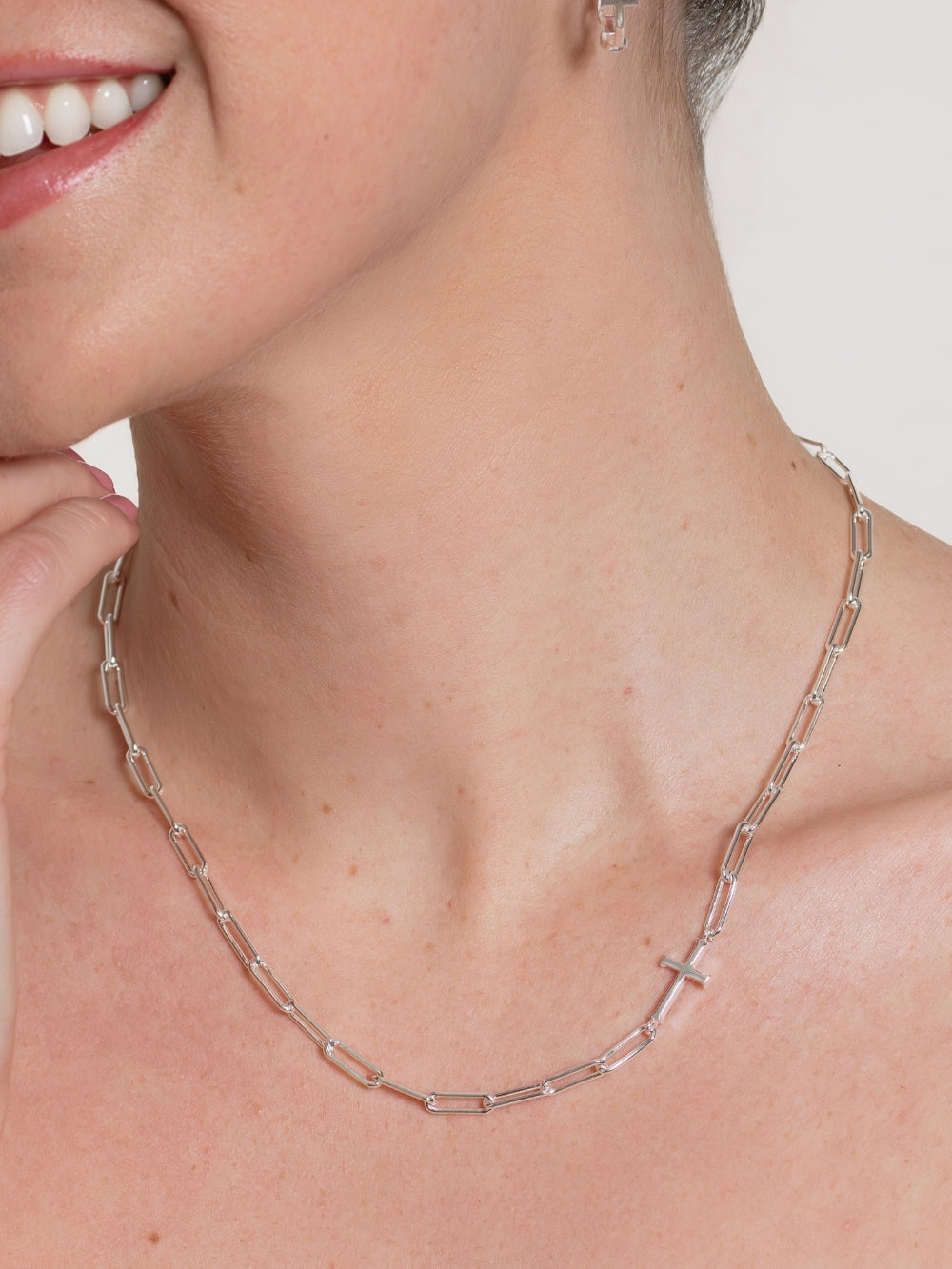 Women's Christian jewelry model wears the Silver Paper Clip Chain Breaker Cross Necklace in Sterling Silver by Rizen Jewelry. 