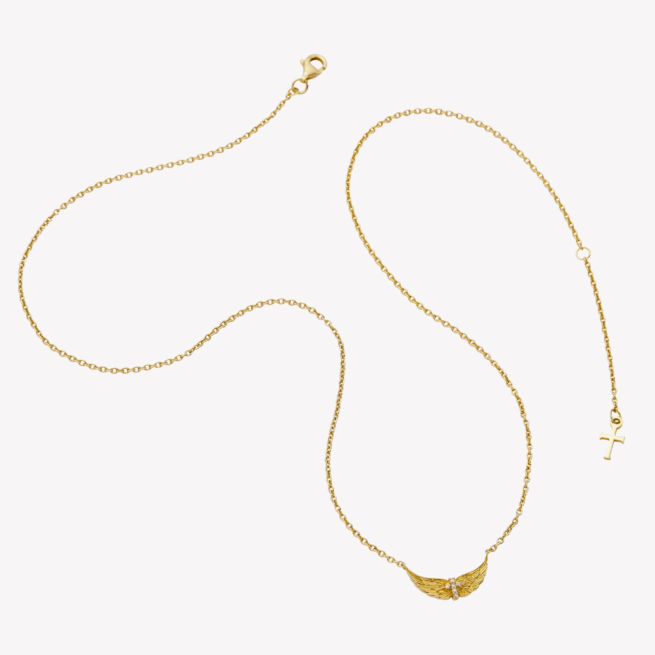18k gold plated over sterling silver necklace featuring uplifted angel wings with a radiant cubic zirconia cross at the center and textured feather detail. Set on an adjustable 19.5 in cable chain with a dainty cross tag pendant. From the Insignia Collection by Rizen Jewelry.