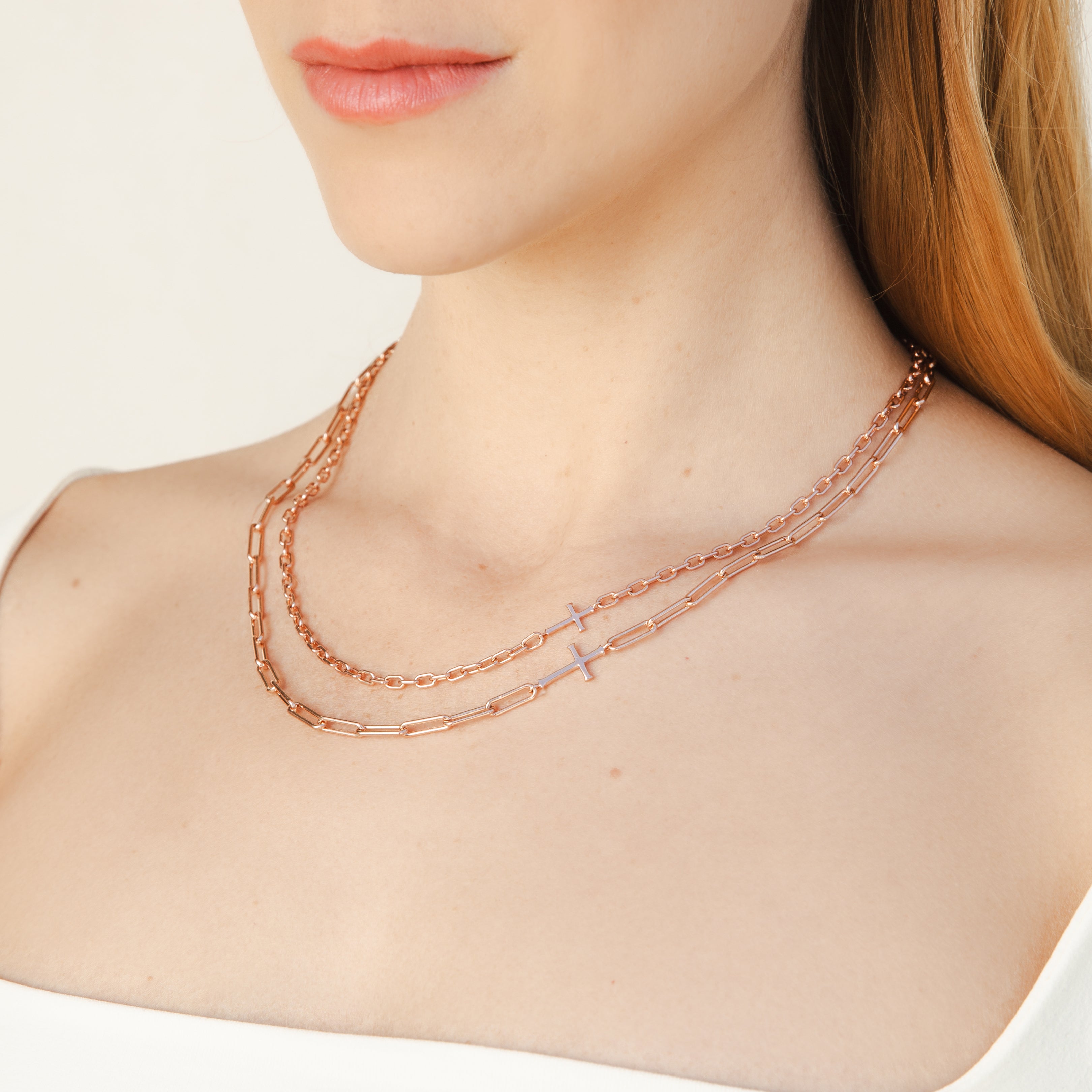 Mini Chain Breaker Cross Necklace in 18k rose gold vermeil from the calvary collection by Rizen Jewelry layered with the Original Chain Breaker Cross Necklace on a Christian Woman. 