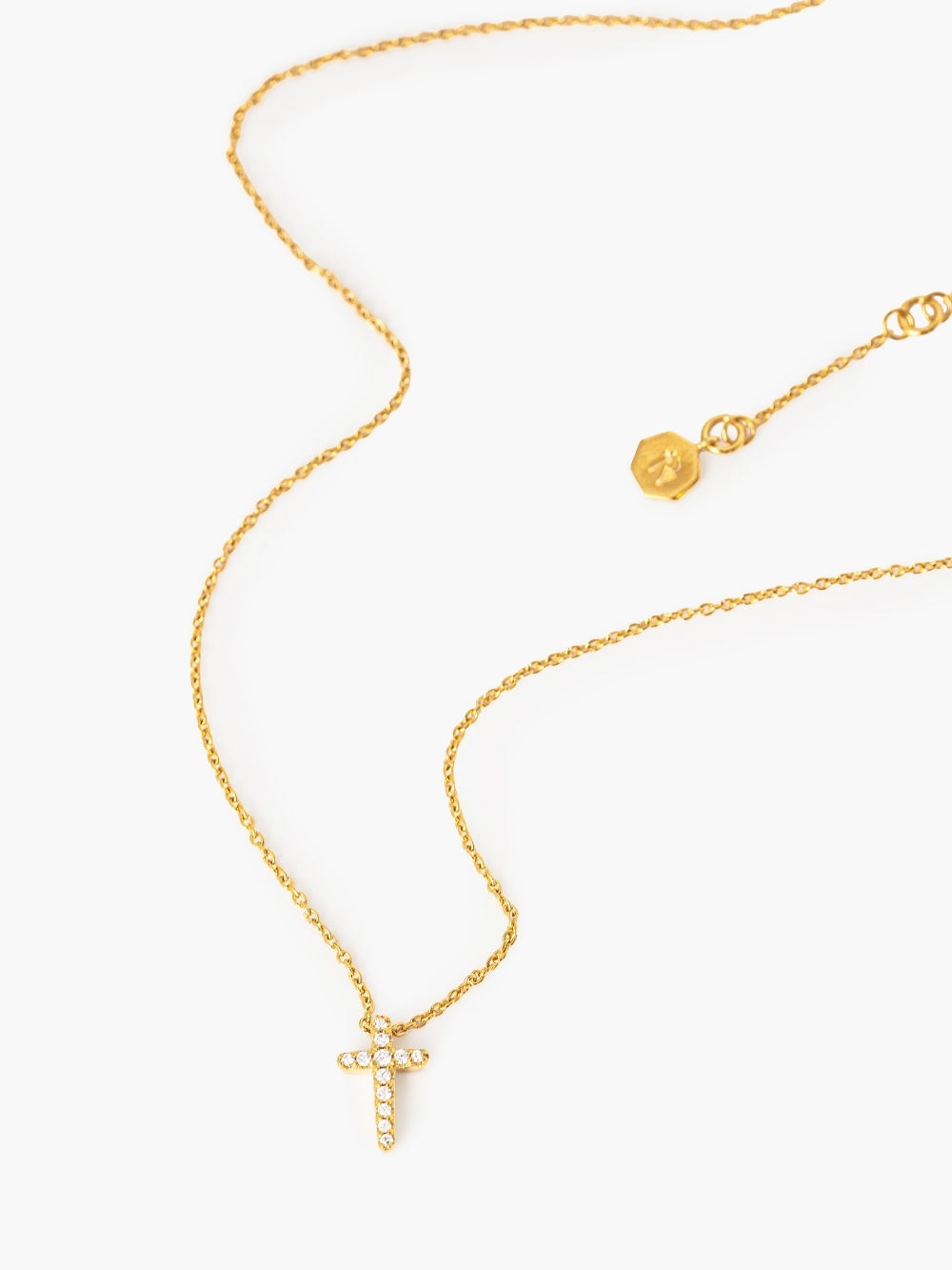 Close-up of pavé-set cross pendant, 7.2mm by 11mm, showing the largest center stone on an 18k gold-plated cable chain by Rizen Jewelry